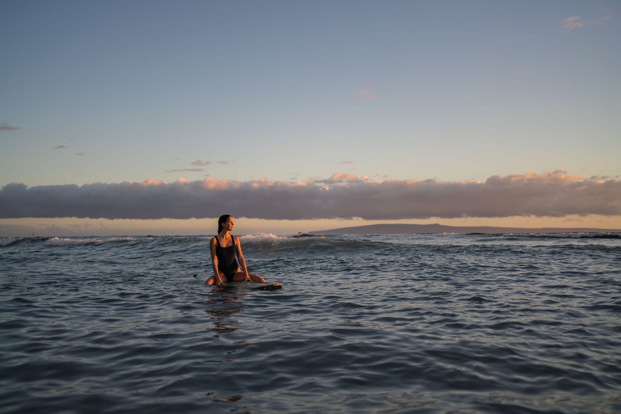 Female surfer waits for waves in tropical waters