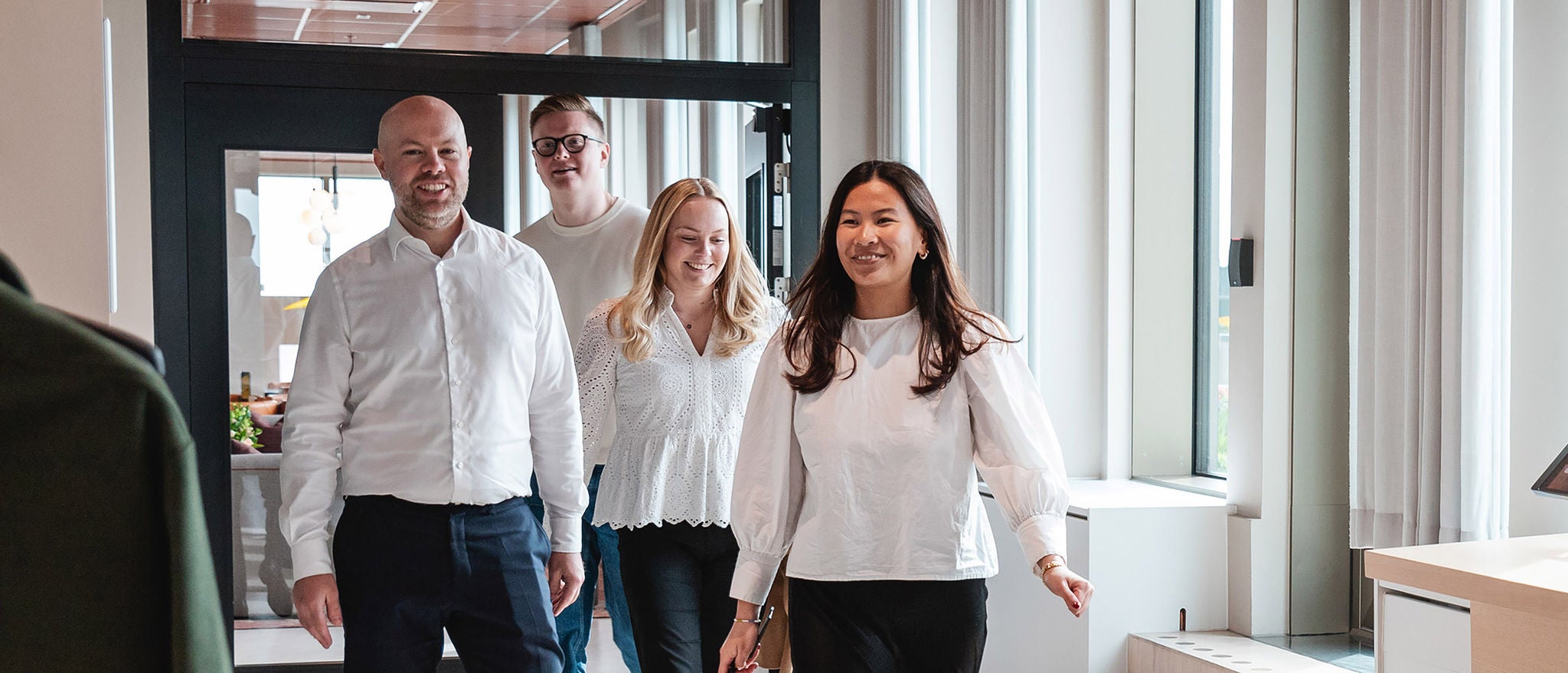 Professionals walking together through modern office reception area
