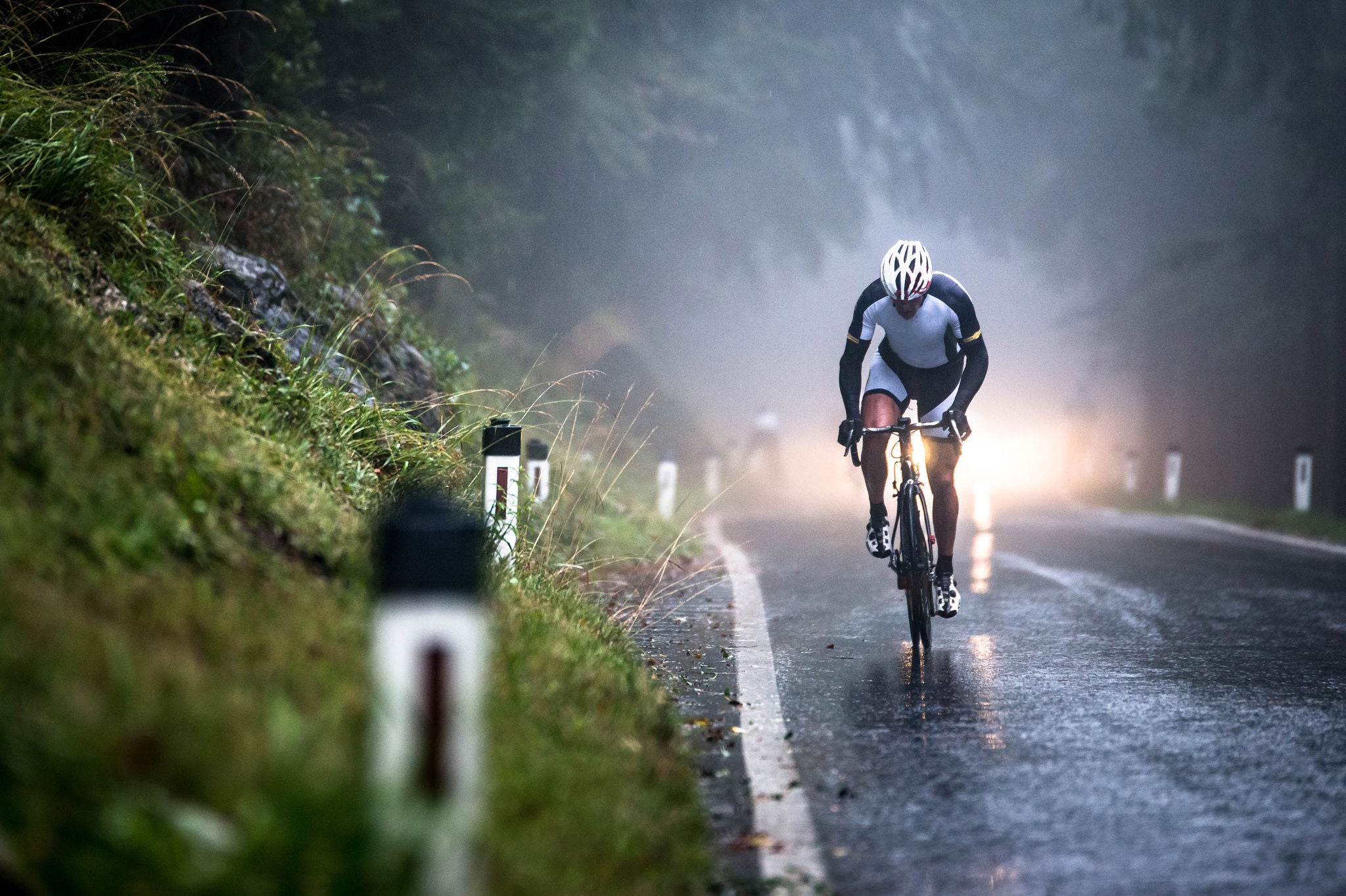 Man cycling on a wet road in rain Salzburg Austria