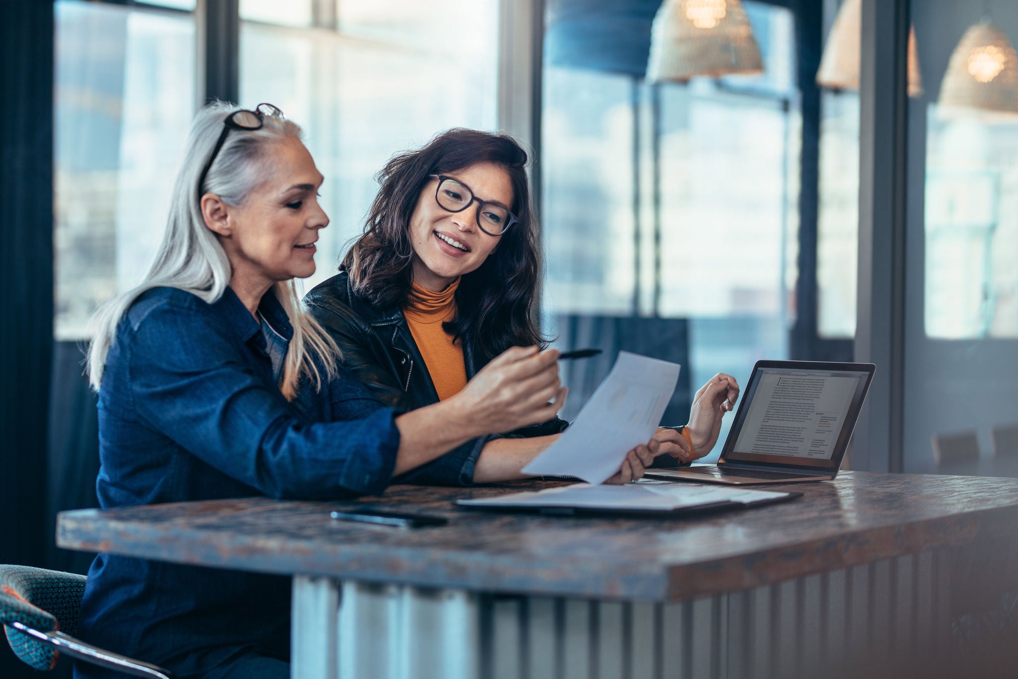 Two women discussing about documents in office