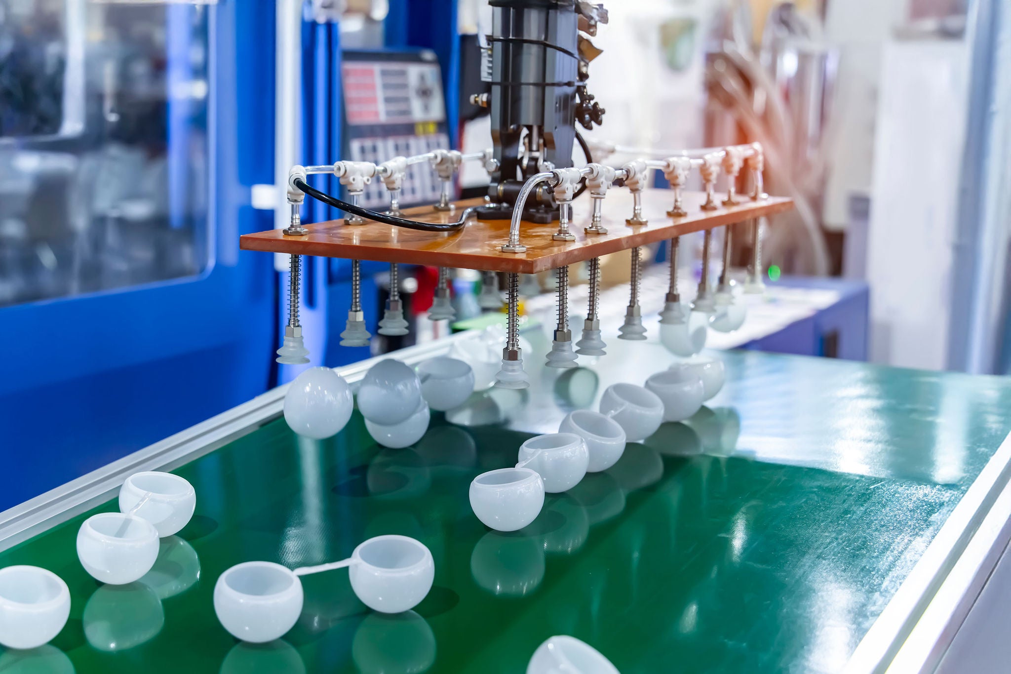 Stack of polypropylene containers on conveyor belt of automatic plastic injection molding machine