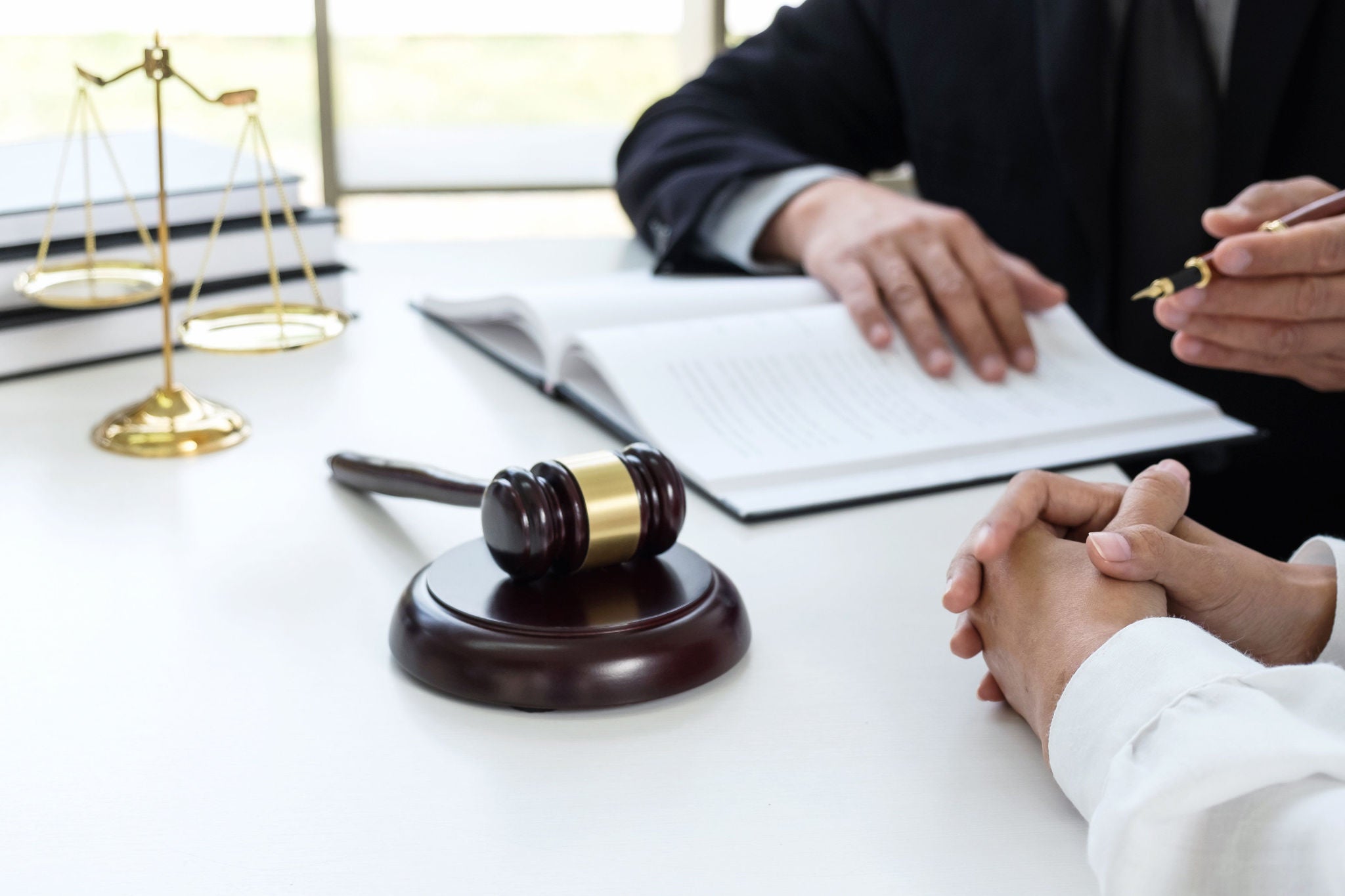 Male lawyer or judge Consult with client and working with Law books, report the case on table in modern office