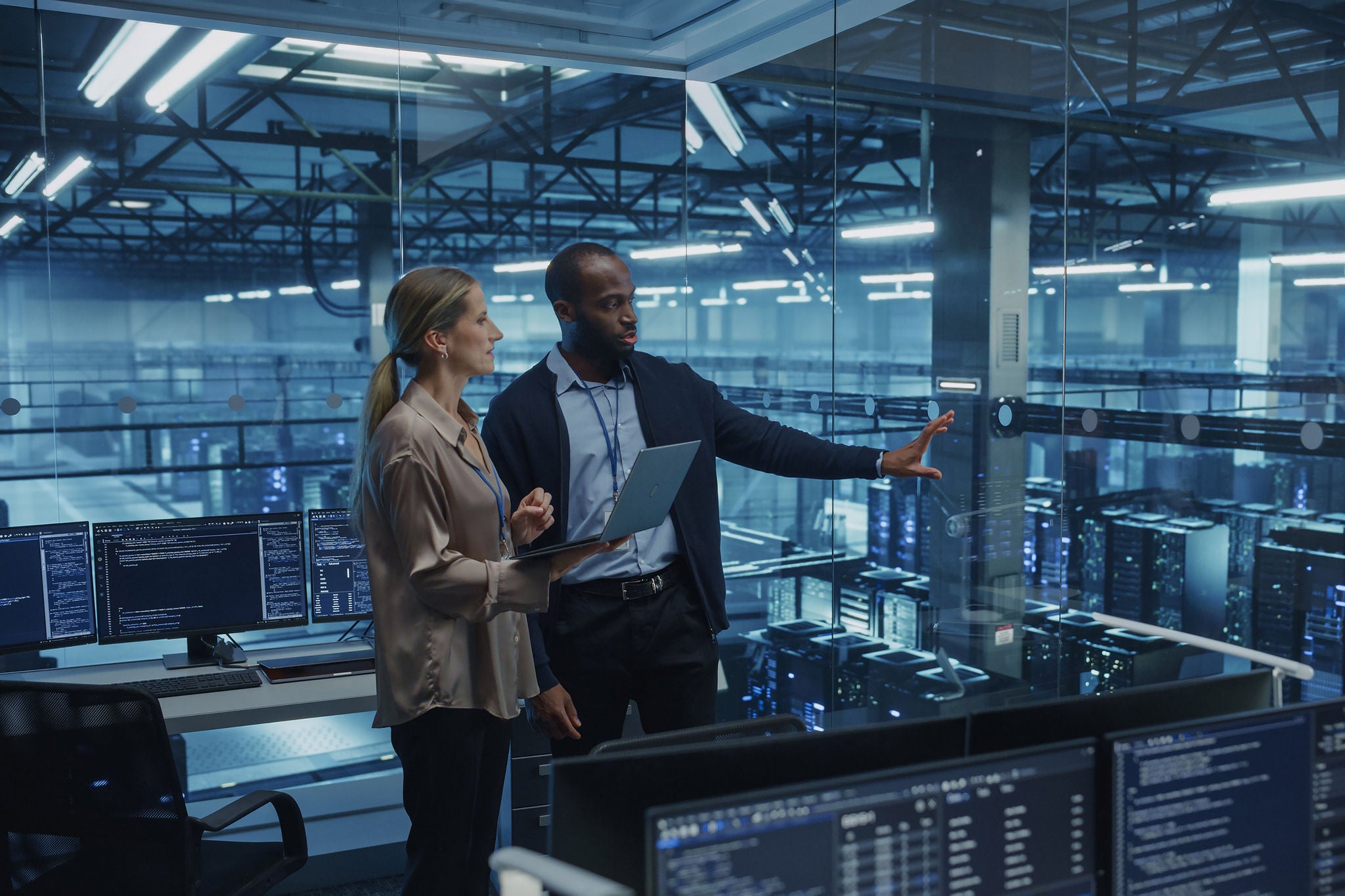High-Tech Data Center Team Reviews Security Logs on Laptop, Strengthening Network Defenses Daily