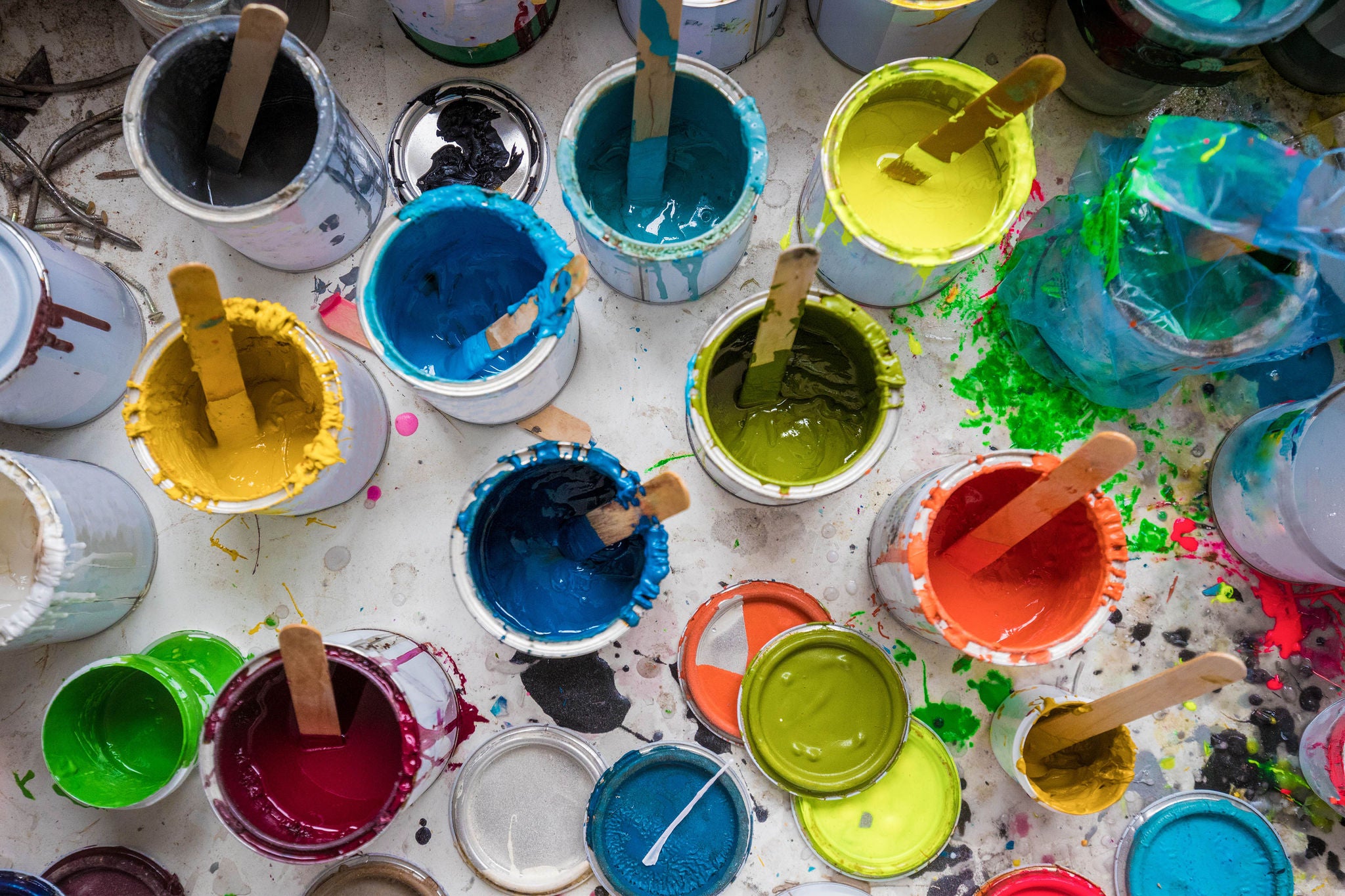 Overhead view of stirrers in paint pots in surfboard maker's workshop