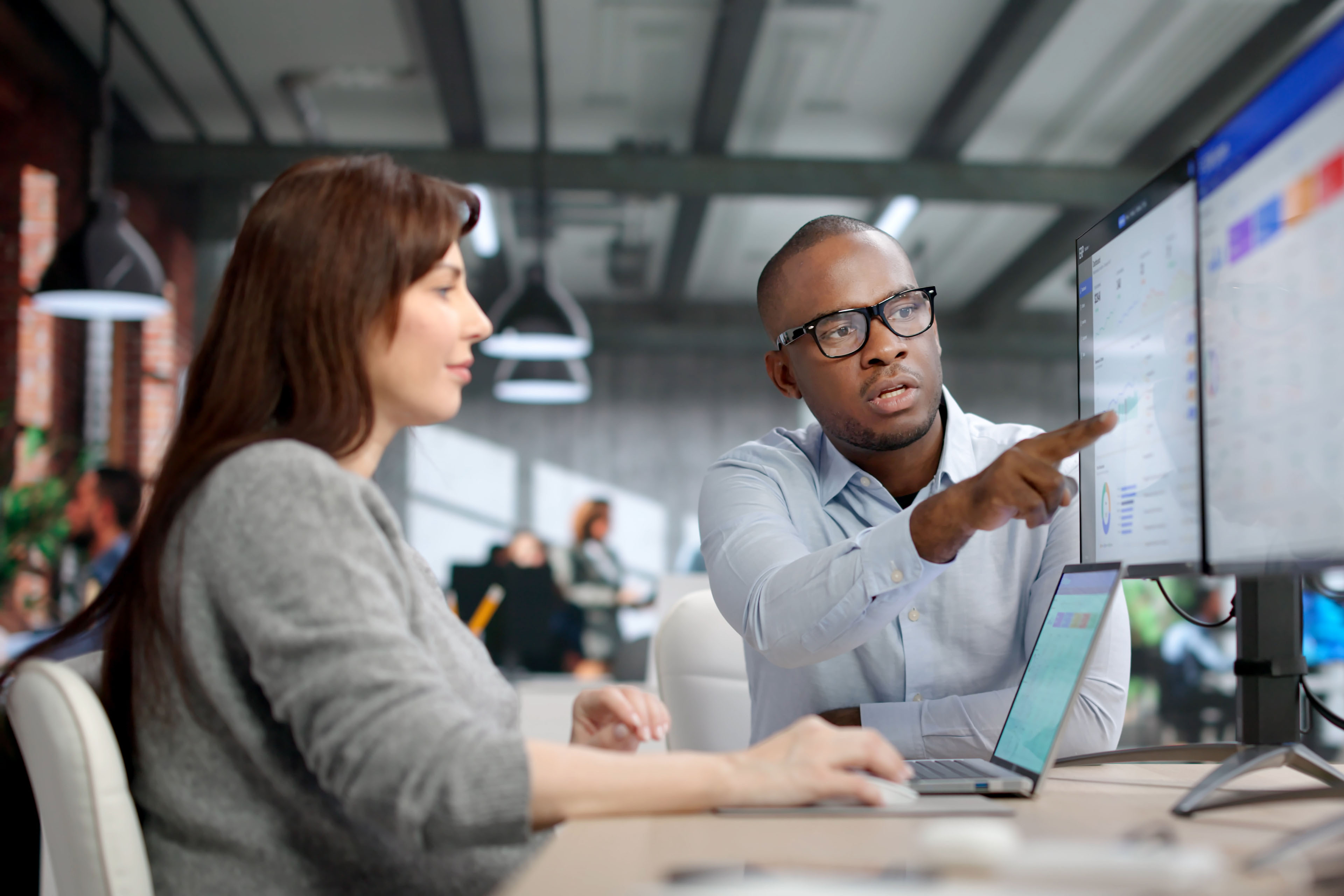 Two Young Professionals Collaborate Using ERP And CRM Software For Business Management, Data Analysis