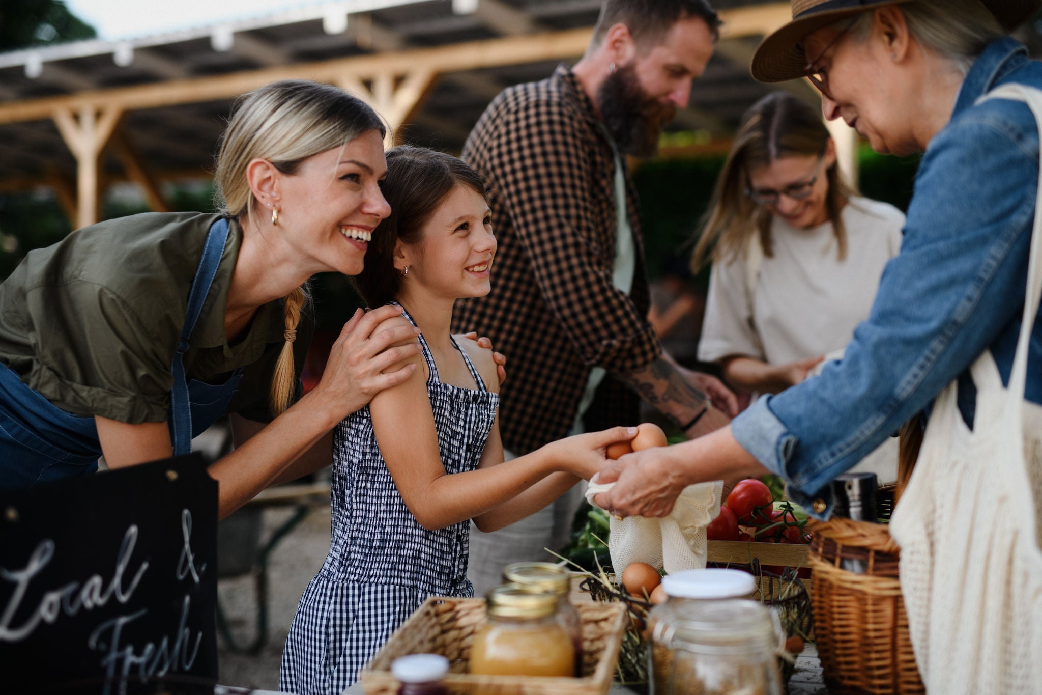People exchanging goods at a busy outdoor market stall