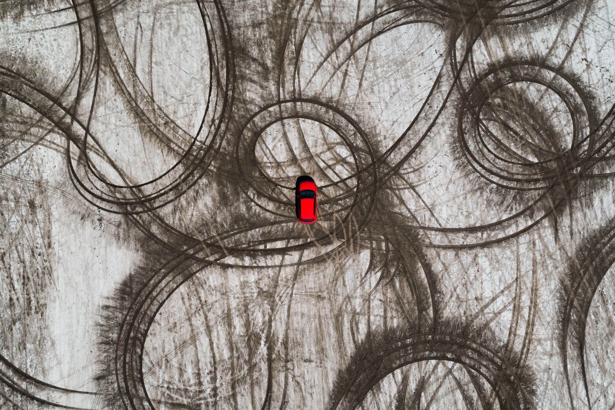 Red car and tire imprints on a beach as seen from above, Gruissan, France