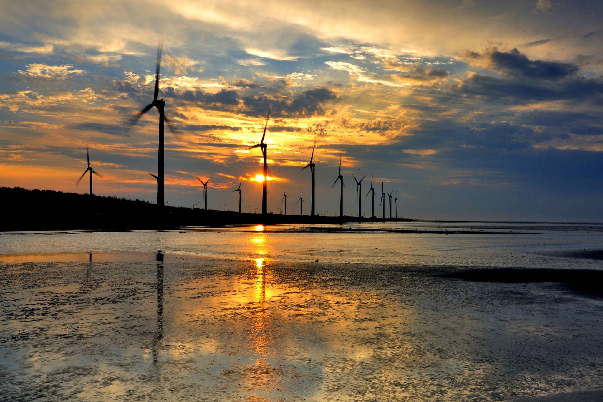 Wind turbines against sunset