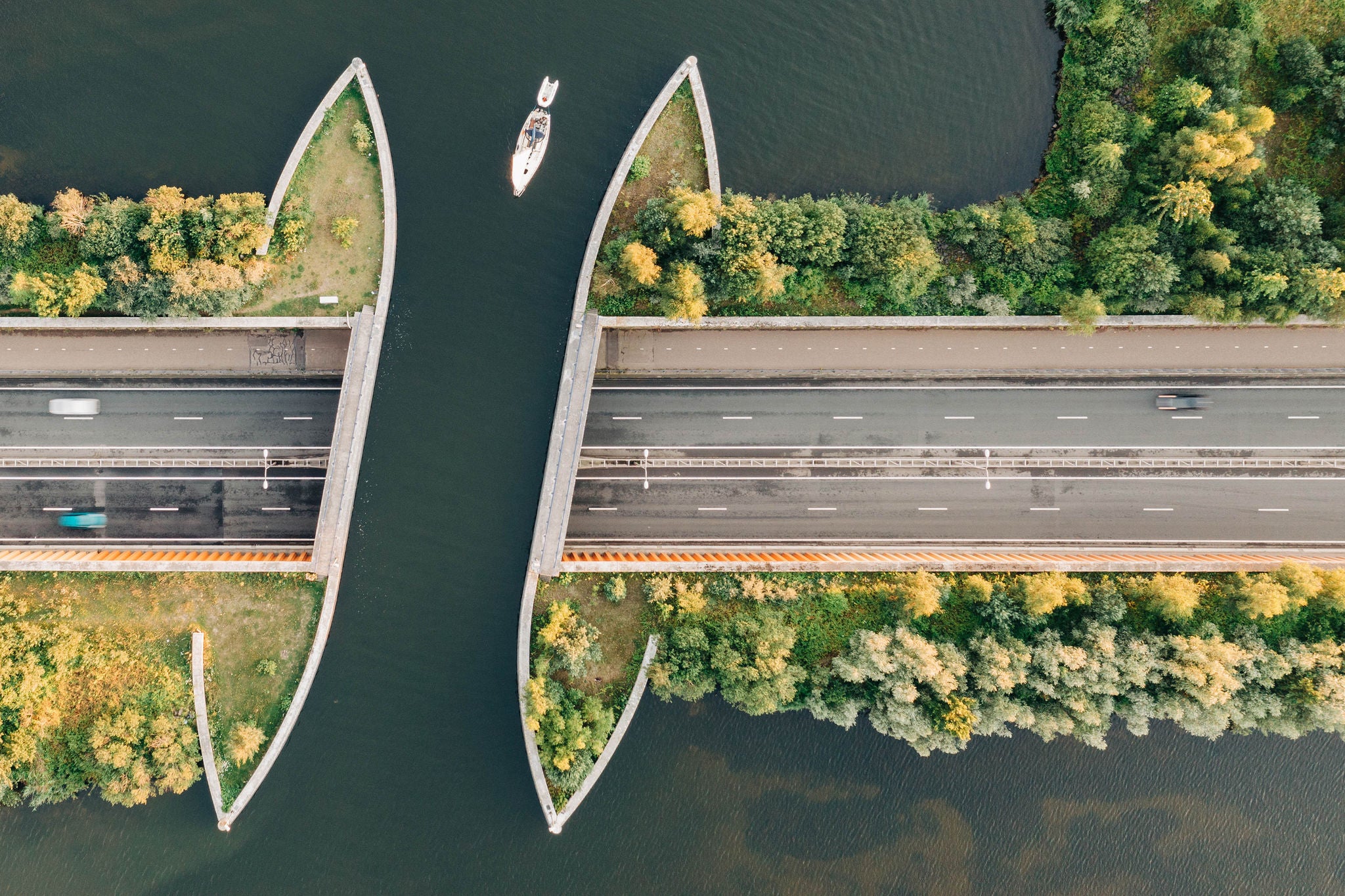 Luftfoto av motorveibro over vann med båt som passerer