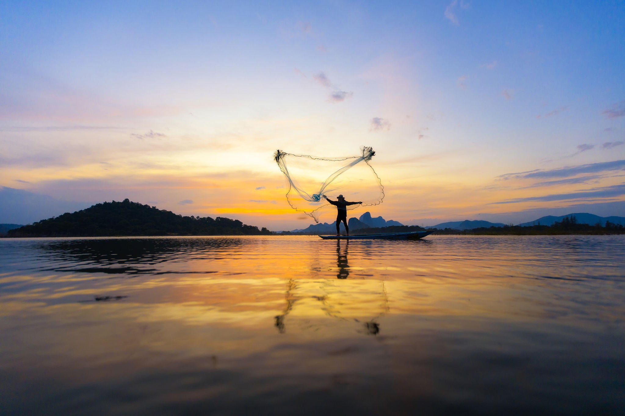 Foto af fisker der kaster et net