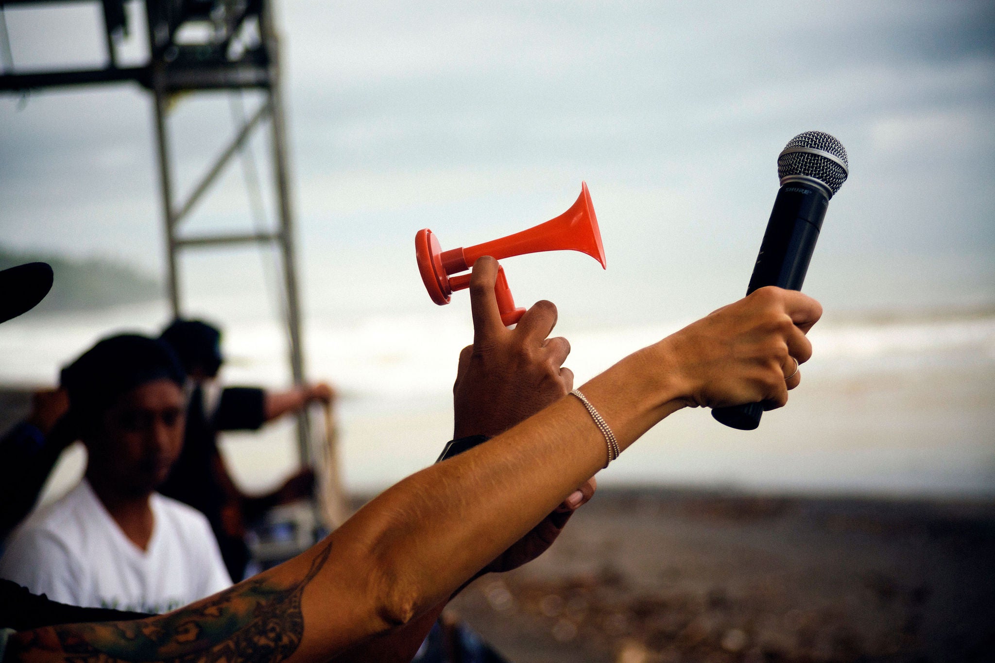 Cropped image of people holding microphone and an air horn