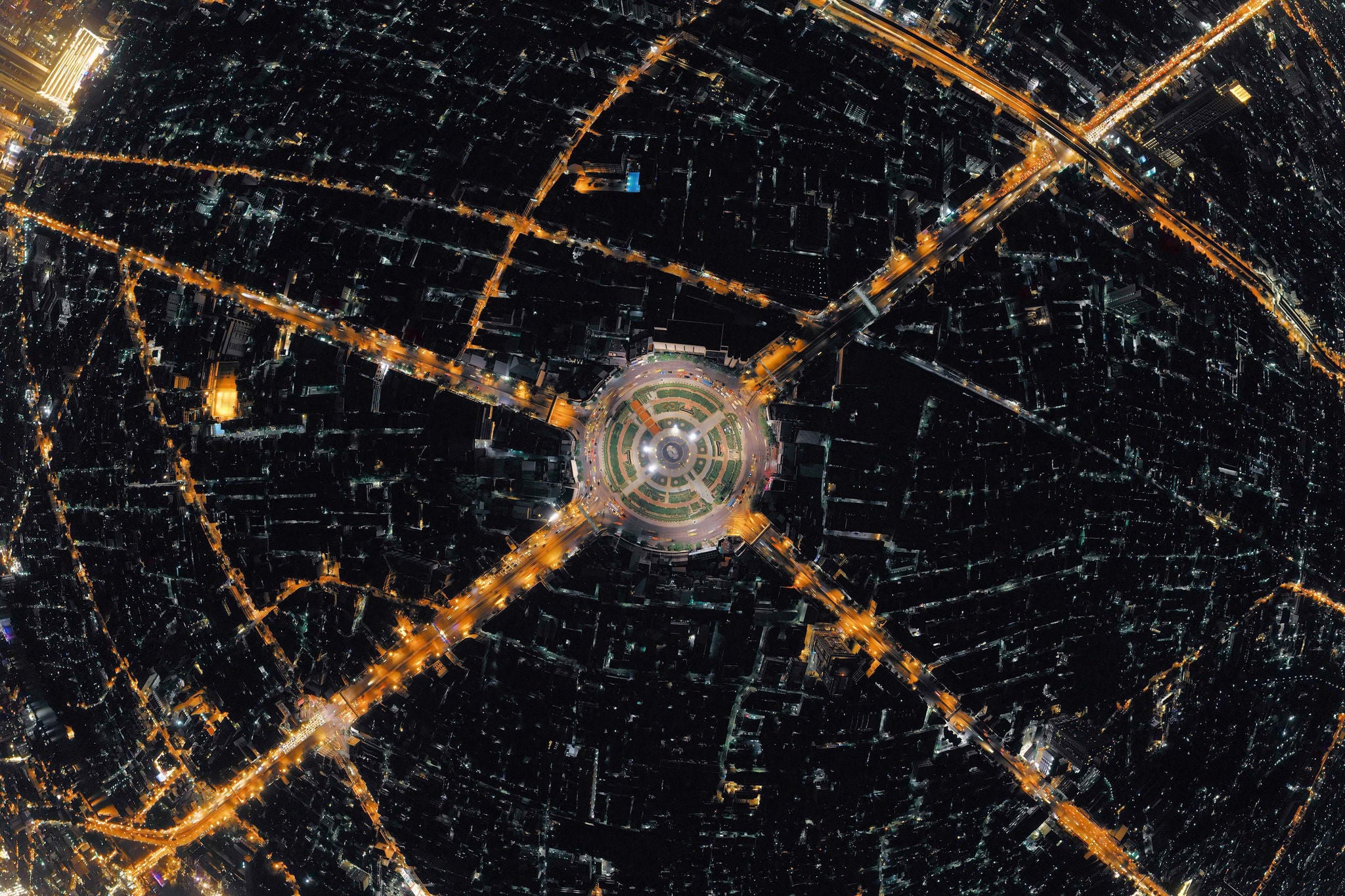 Aerial view of a roundabout and illuminated roads at night in Bangkok