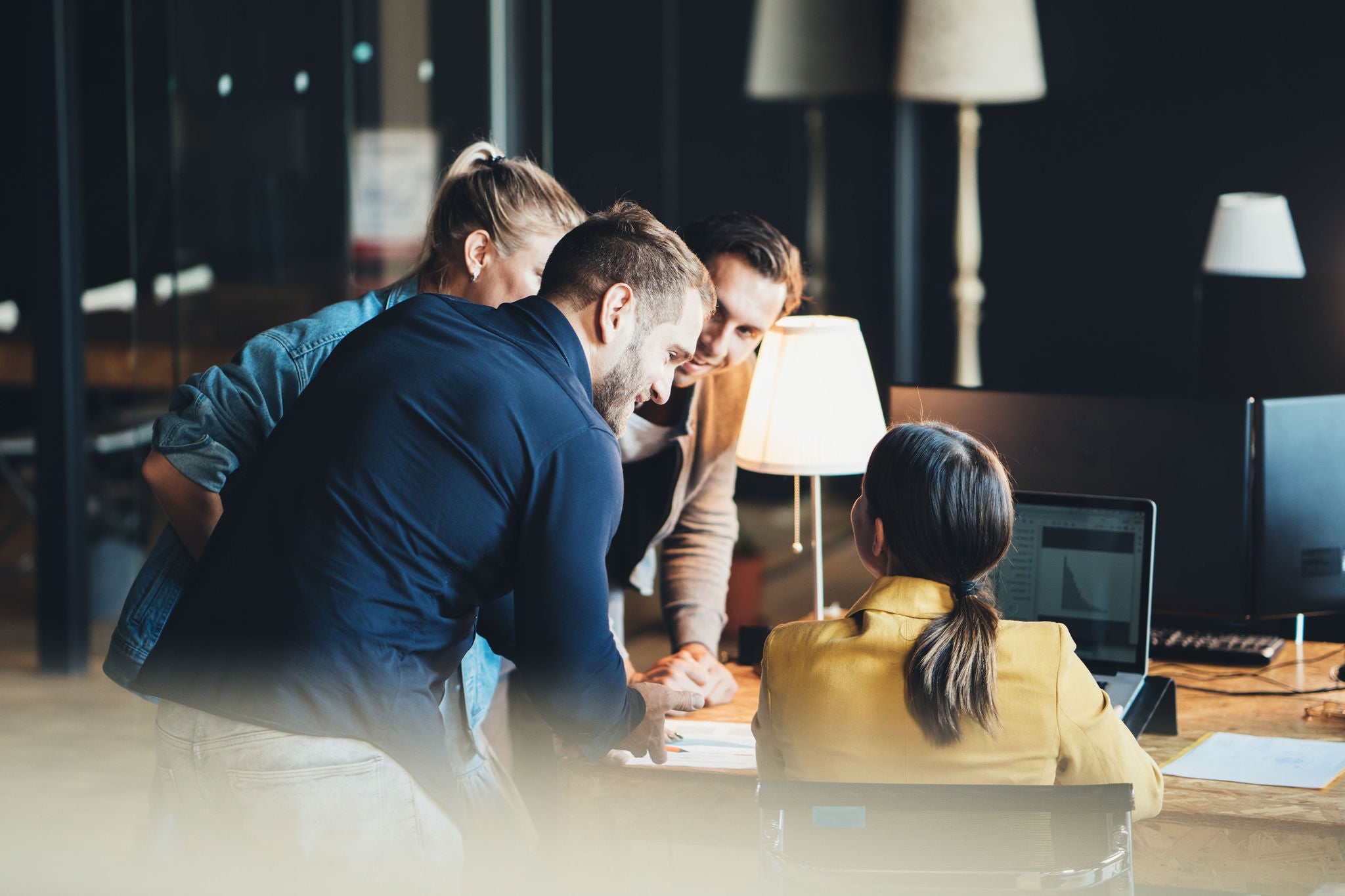 Group of young people in big office have a meeting and discussing company stats and sheets