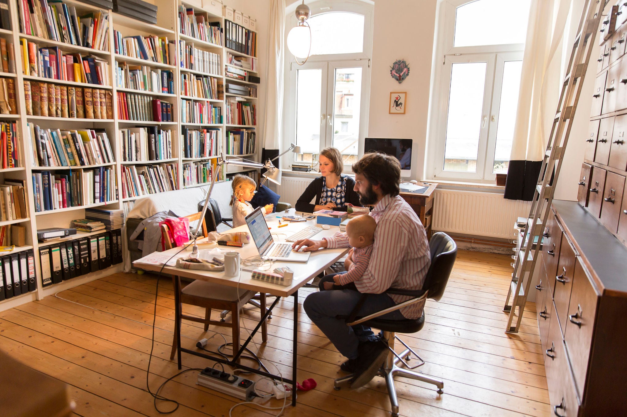 Manlig och kvinnlig designer som arbetar tillsammans med två barn.