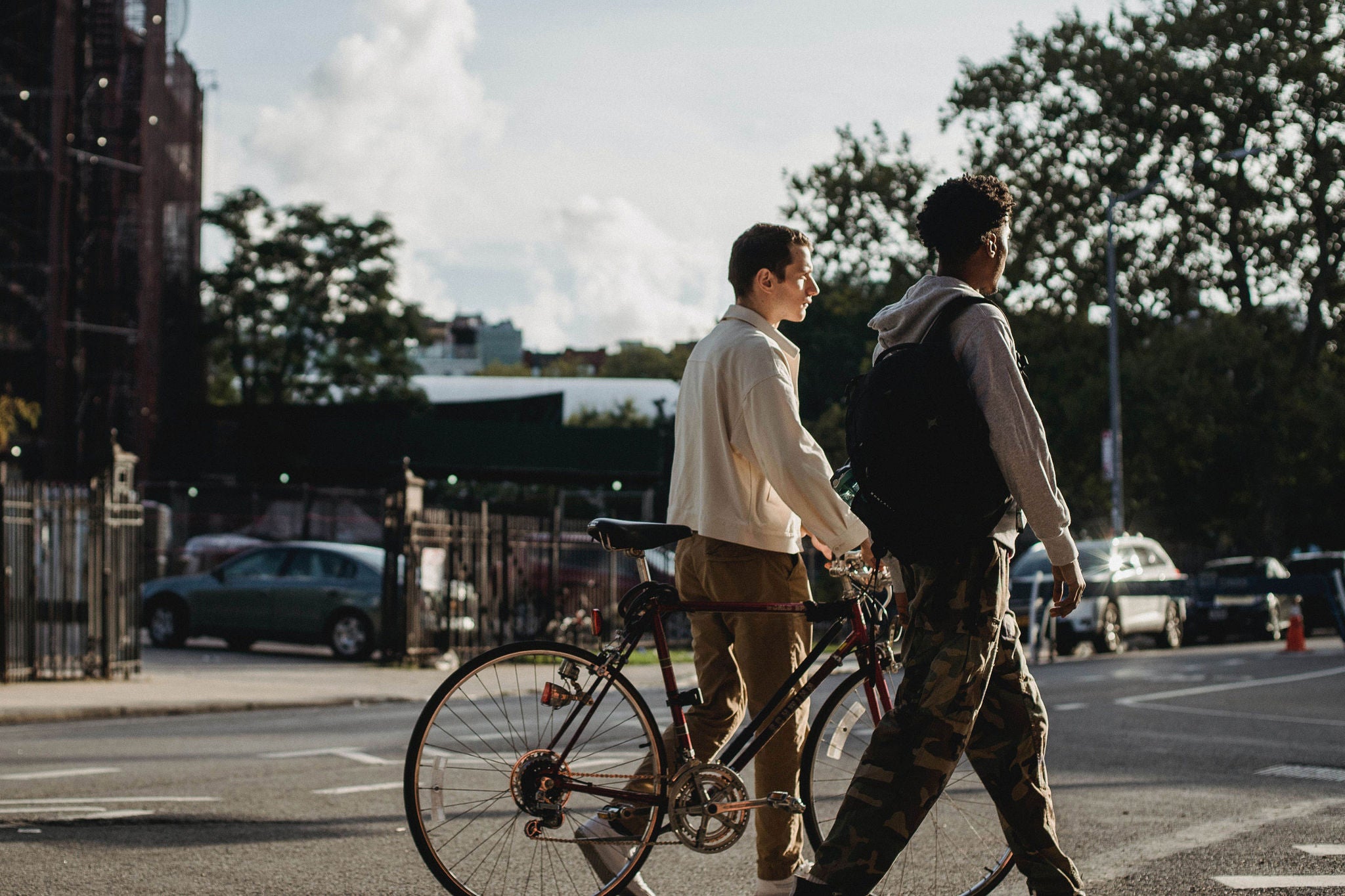 Two young men walking with bike