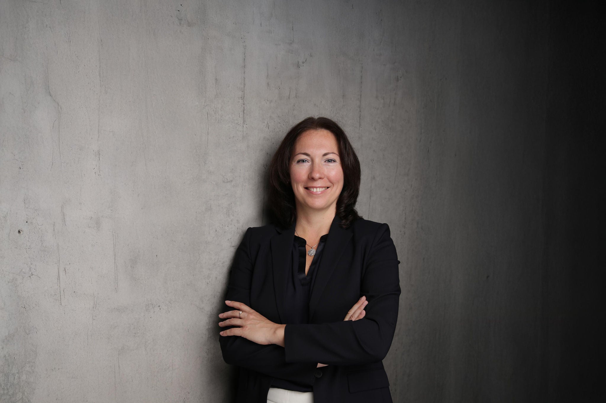 Businessfoto von Frau vor grauem Hintergrund.