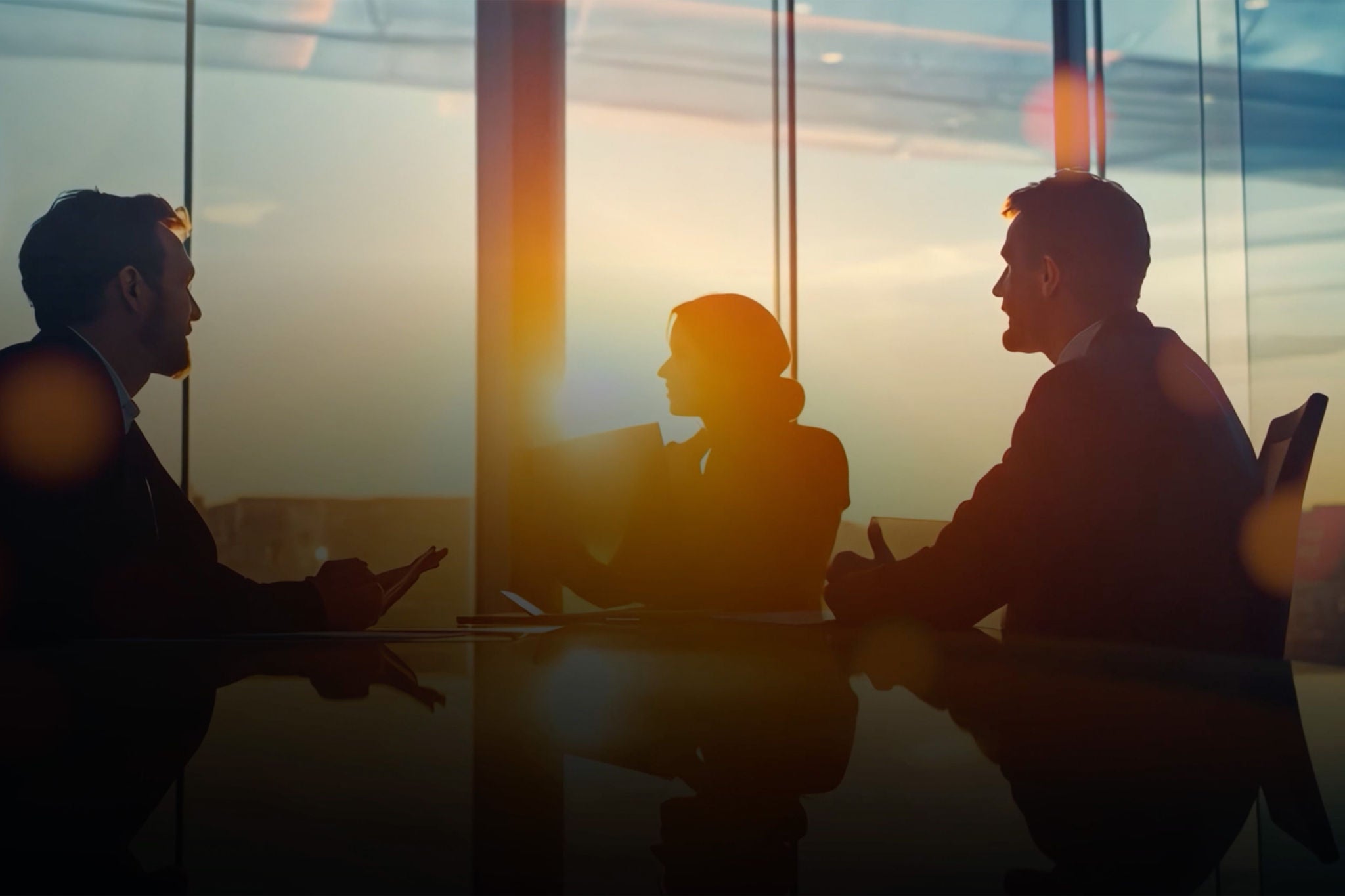 Business leaders in a meeting discussing strategy at sunset