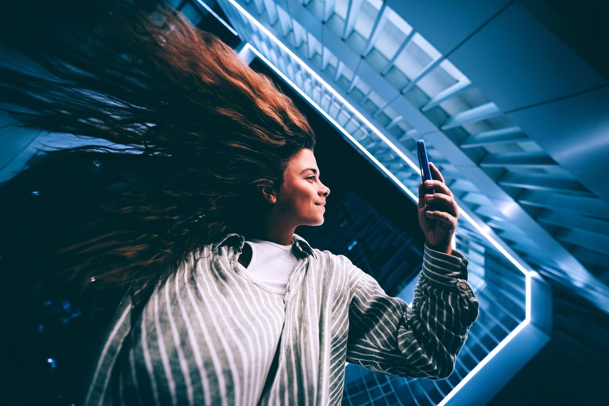mulher olhando para o celular em um ambiente moderno