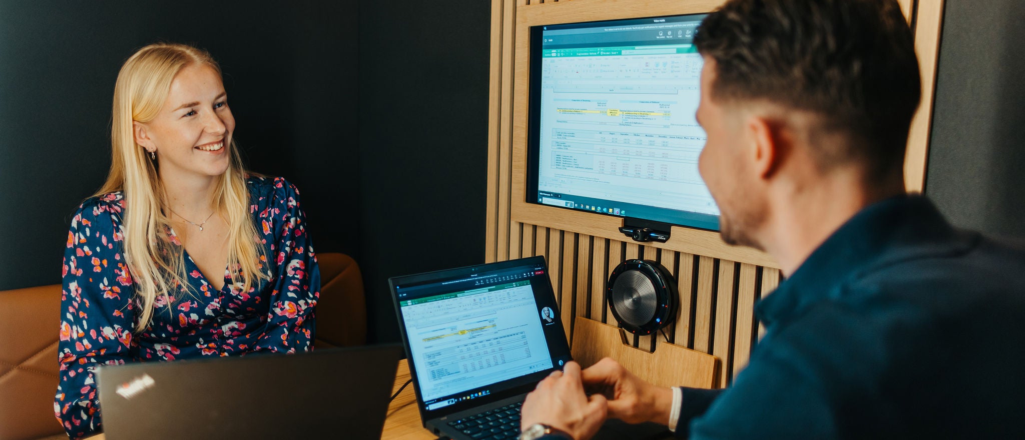 Professionals discussing work while reviewing data on screen in office