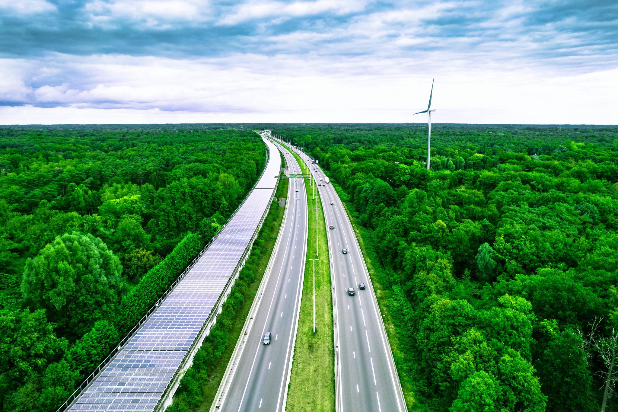 Aerial view of a green highway and railway tunnel covered with solar panels in Belgium
