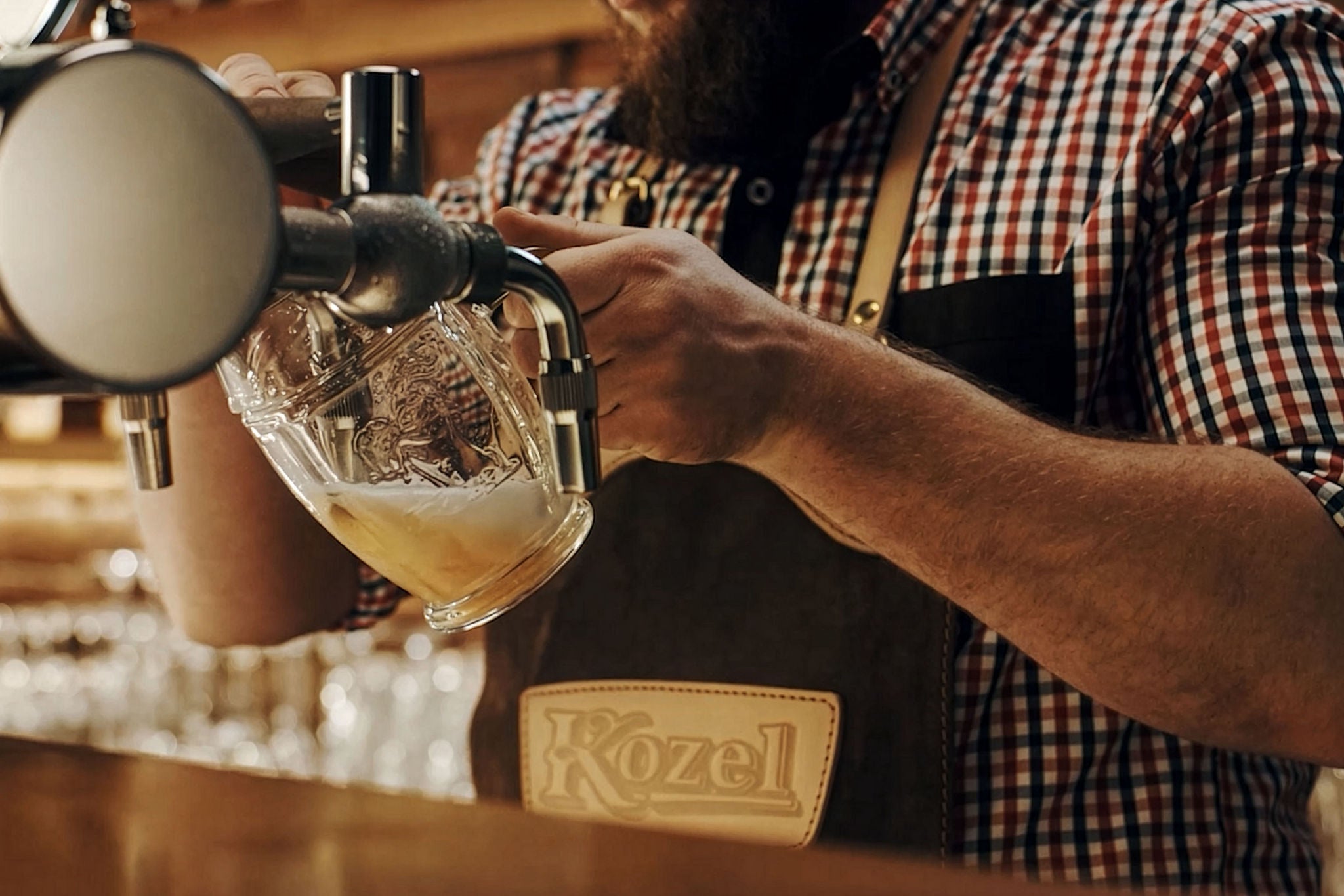 a barman pours a glass of beer in a bar