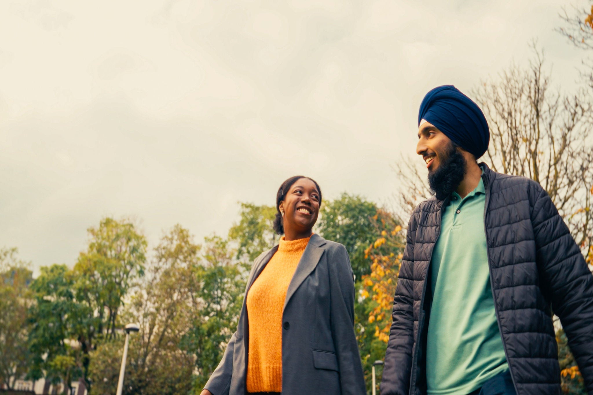 Two people outdoors on a tree-lined pathway