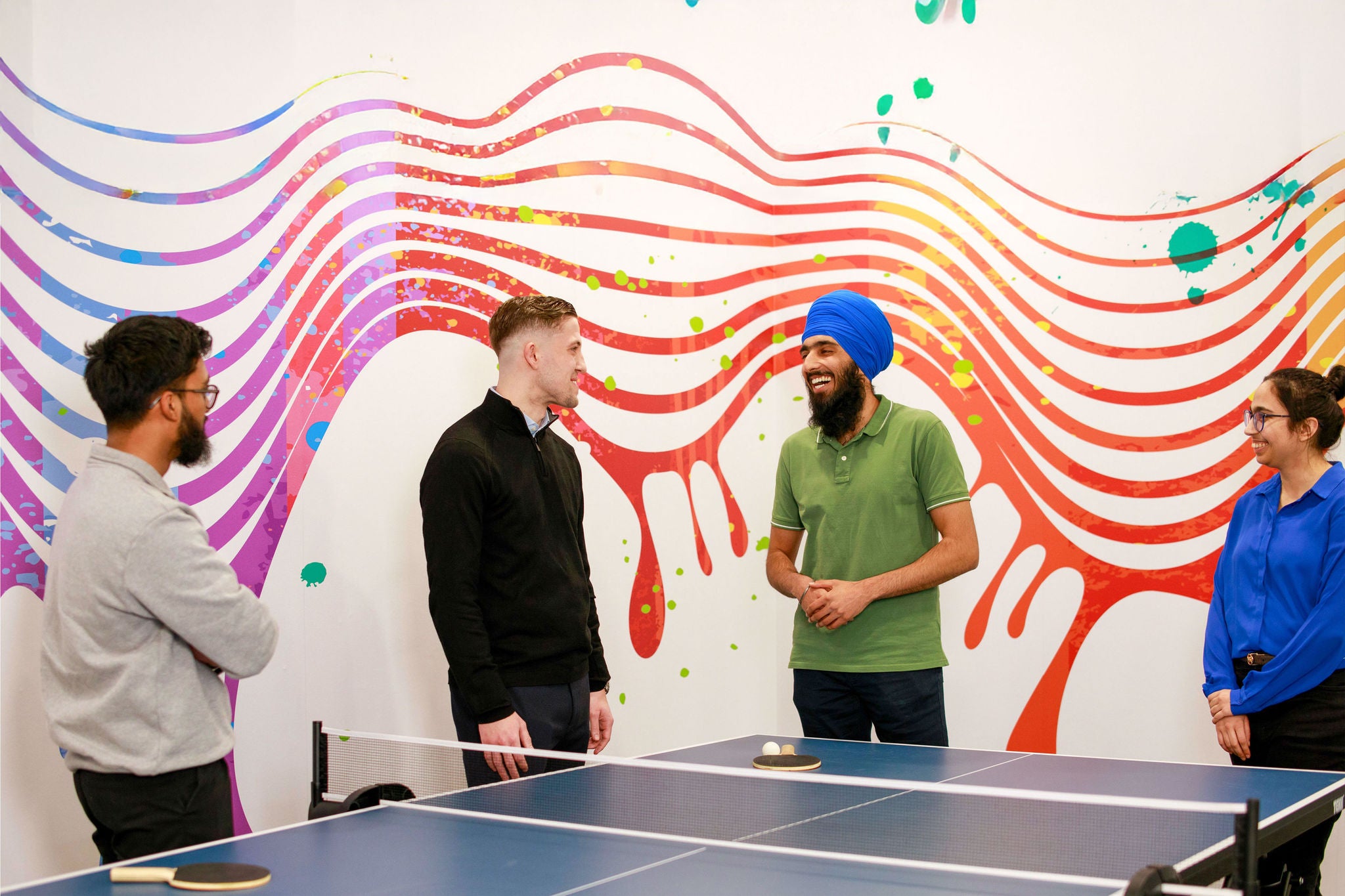Group of people standing by table tennis