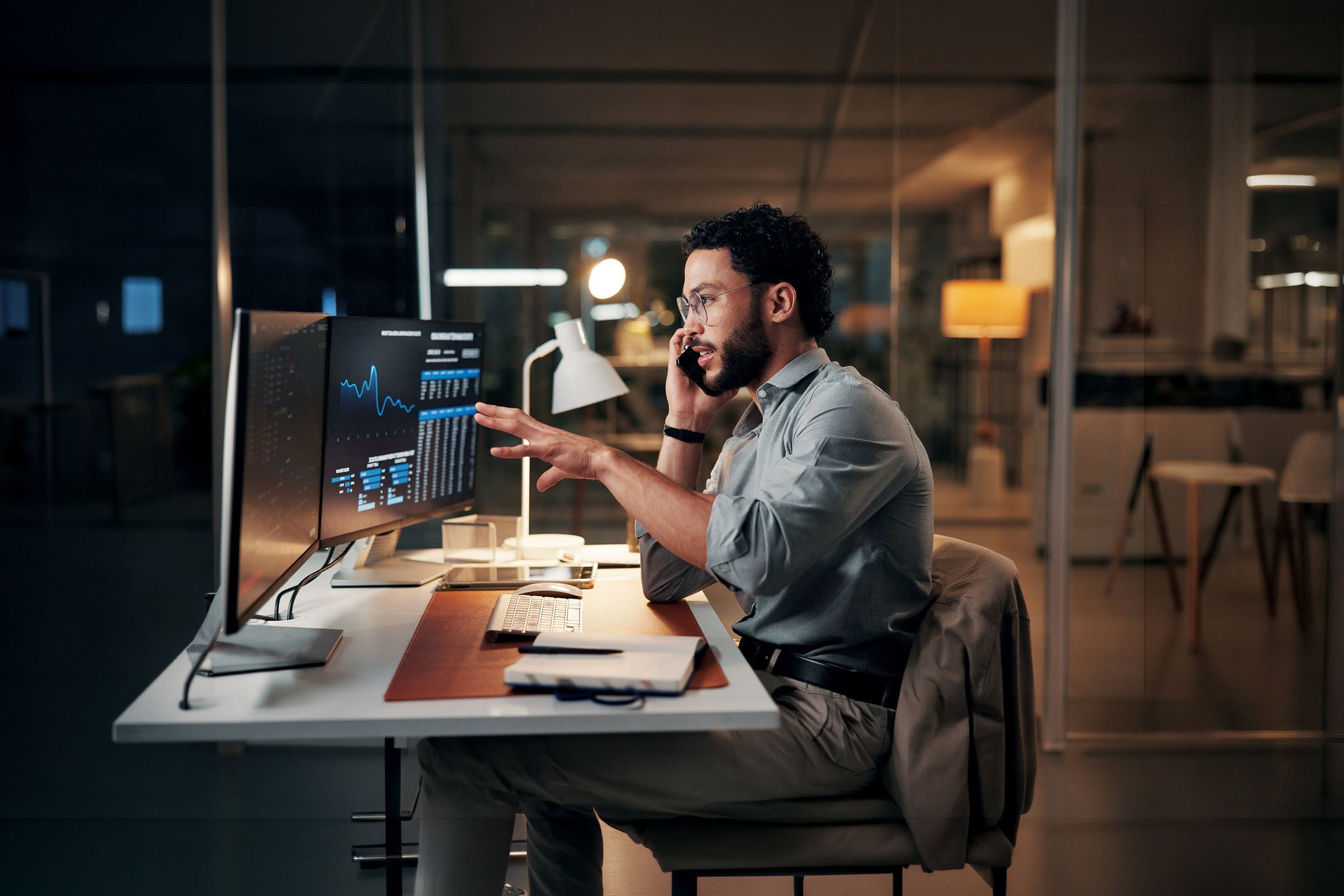 Man, computer screen and phone call for trading, charts and stock market review at night.