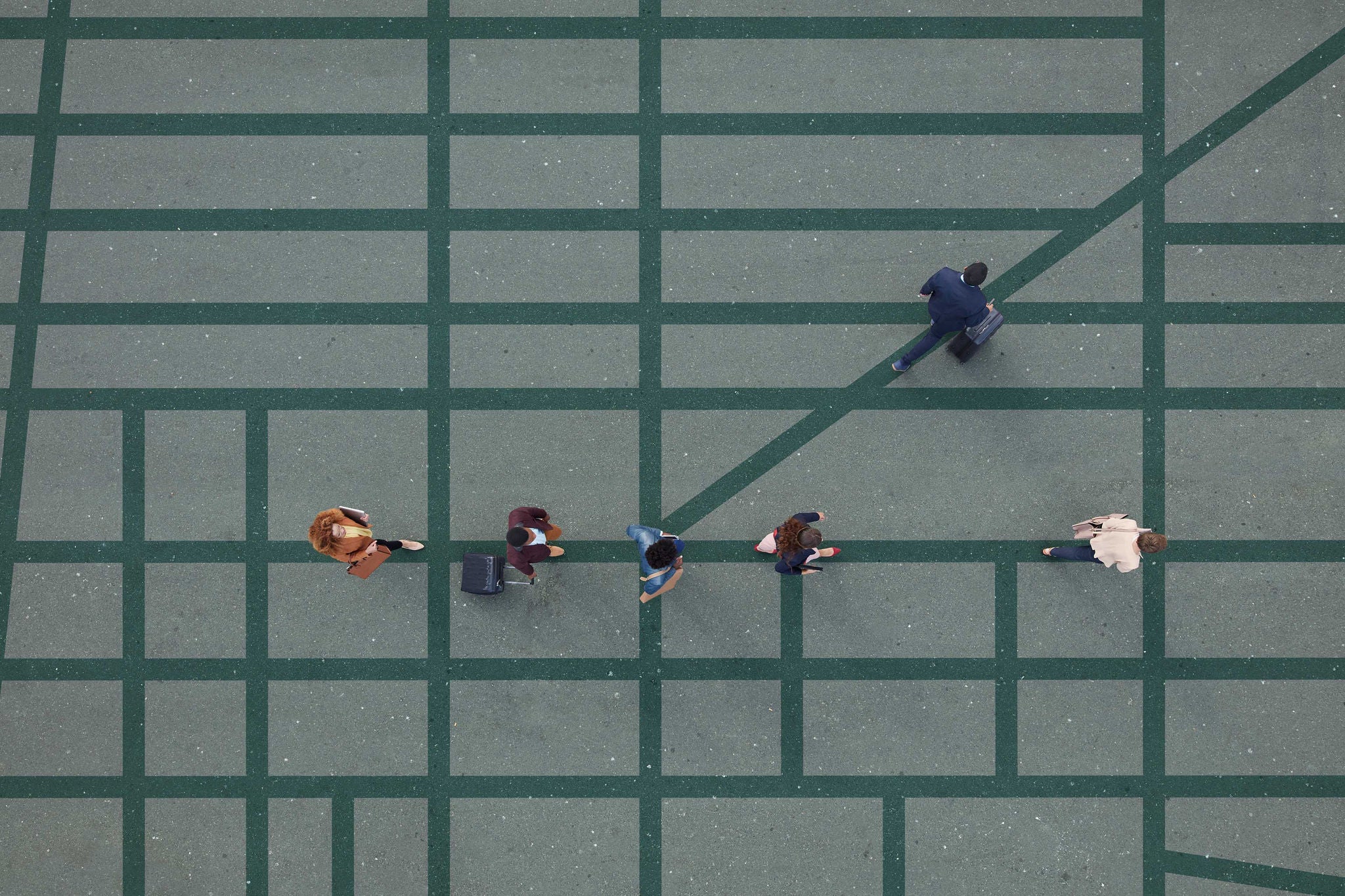 Group of young adults, photographed from above, on various painted tarmac surface, at sunrise.