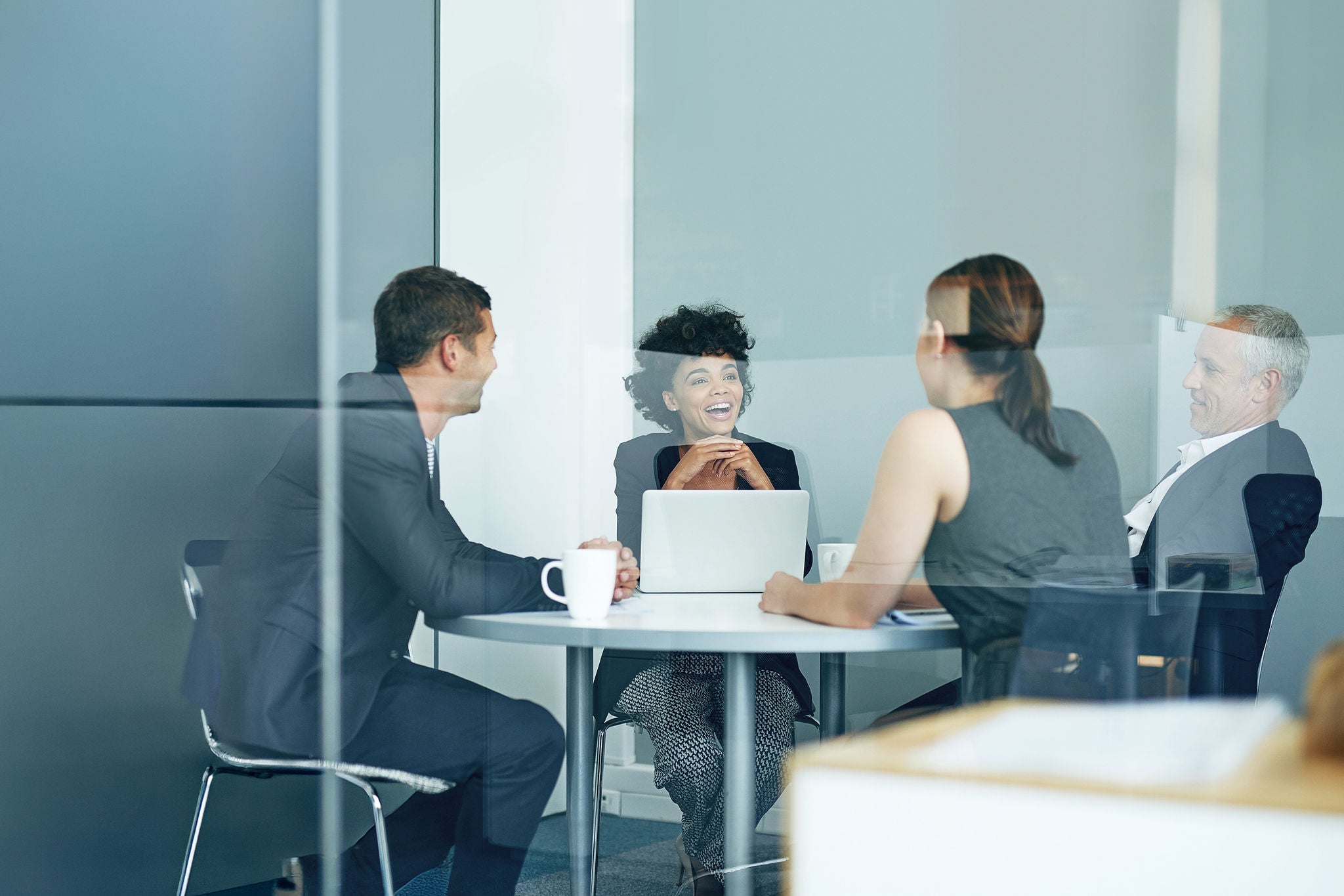 Office, laughing and meeting in boardroom, group and discussion with laptop, coffee and conversation.