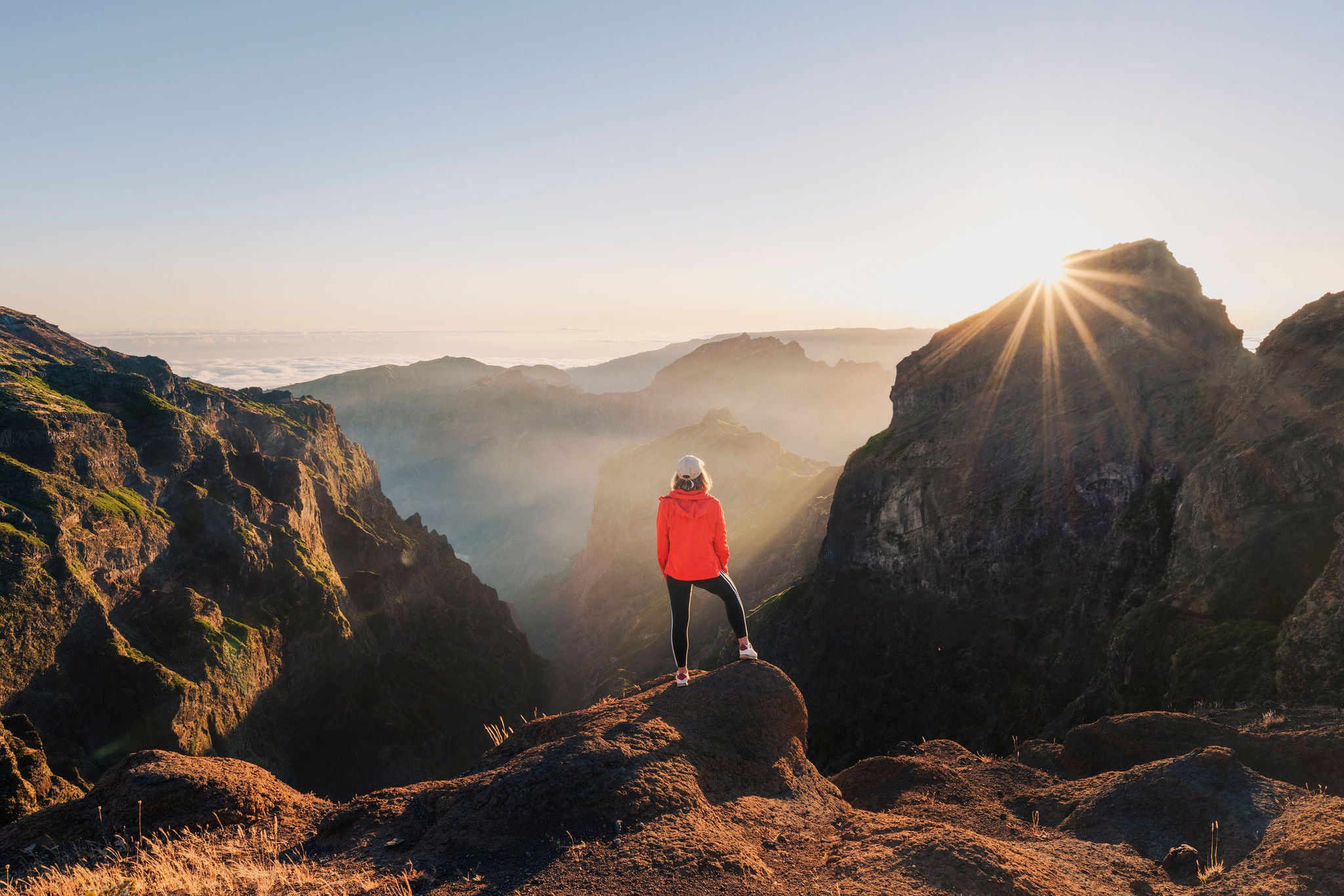 Tourist admiring the sunset from the top of a mountain in Madeira