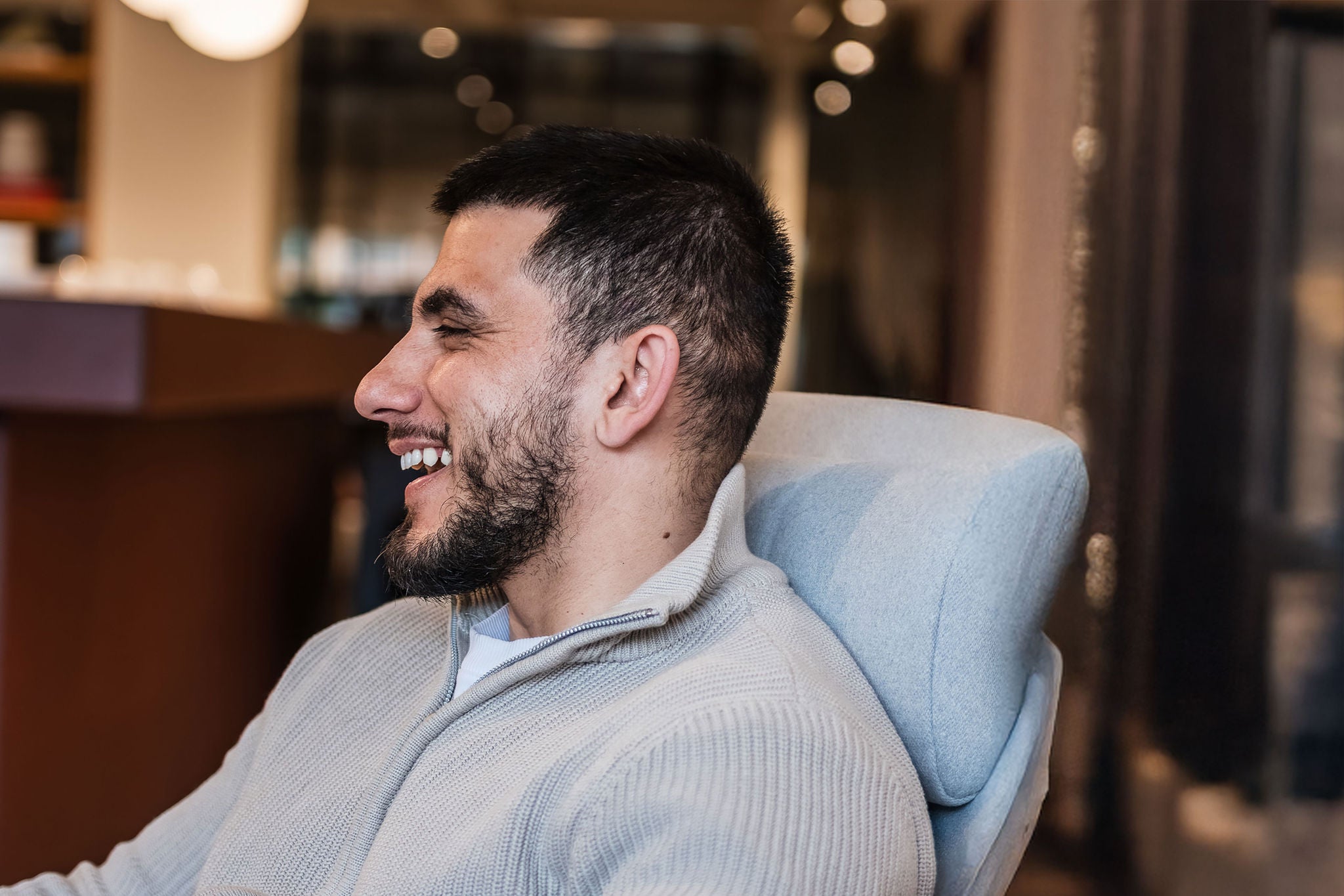Employee seated in a lounge chair in a modern office environment.