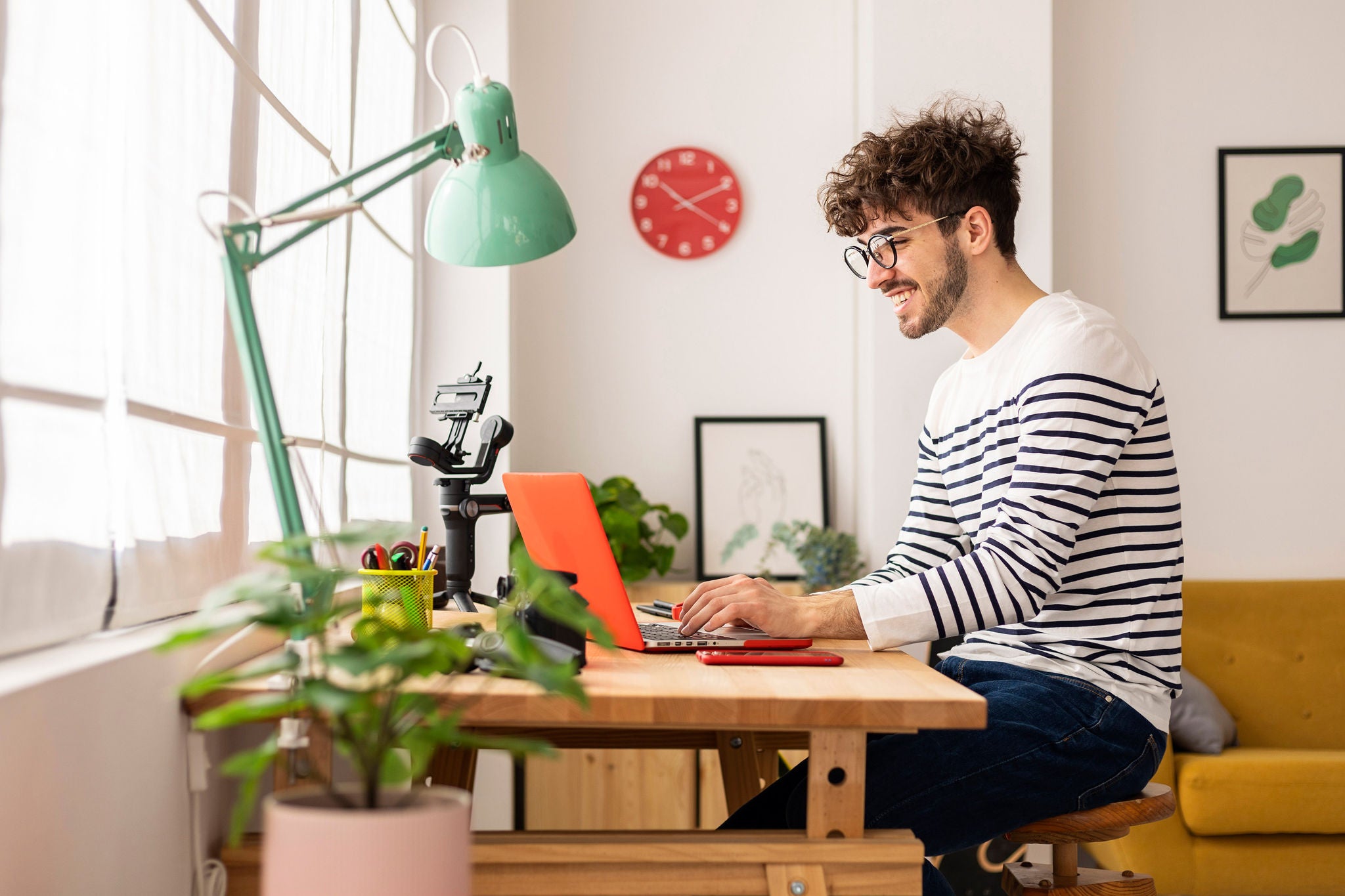 Jonge volwassene studeert thuis en werkt op een laptop aan een bureau