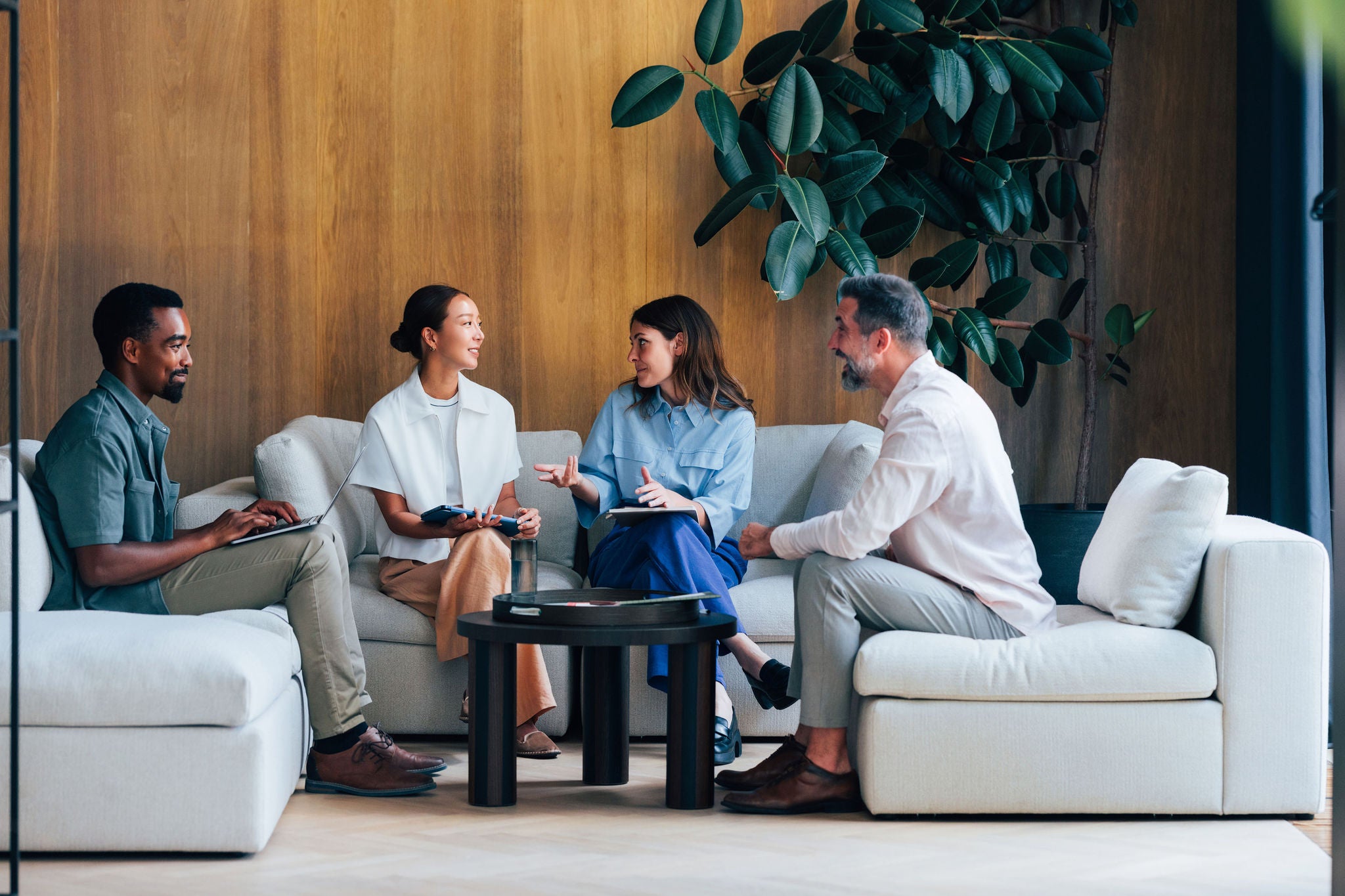 A group of four professionals engaging in a collaborative discussion.