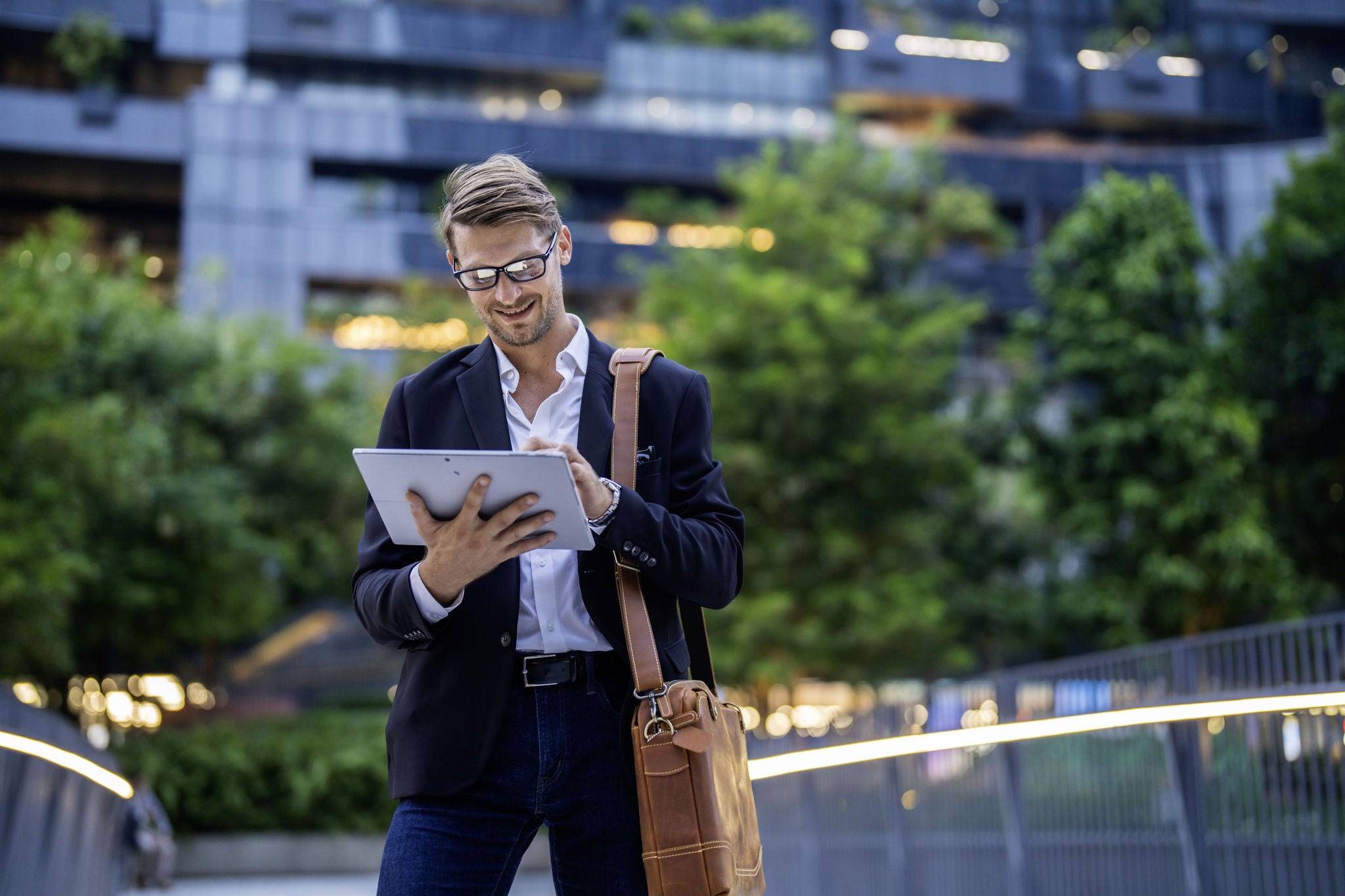 Portrait of businessman in glasses holding tablet
