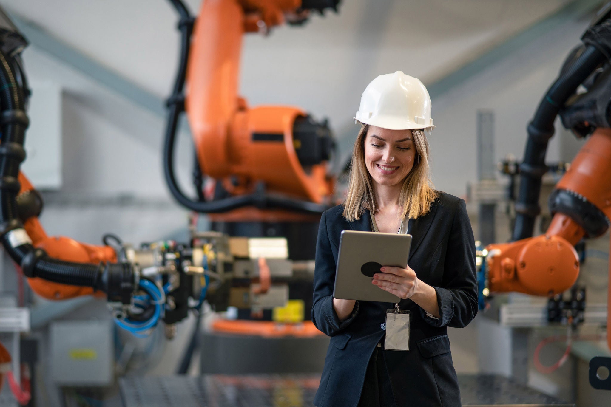 Female chief engineer in modern industrial factory using tablet and making audit