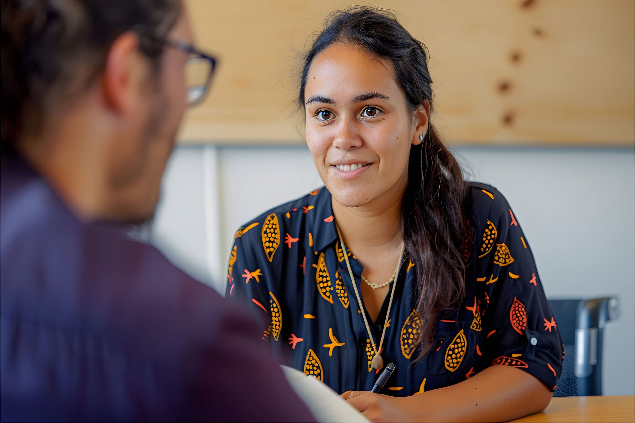 Two professionals engaged in a focused discussion in a modern office setting.
