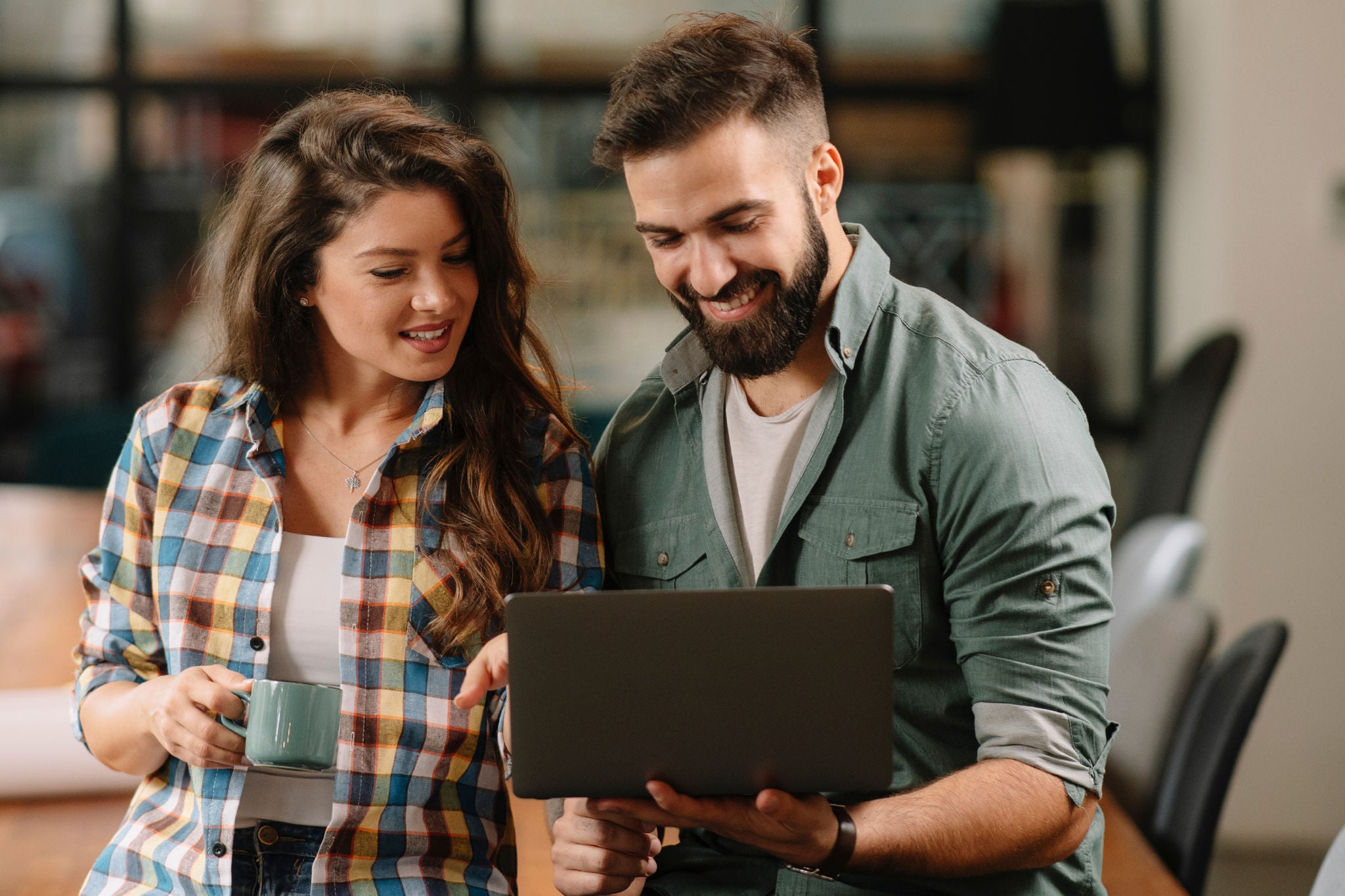 Zwei Personen vor einem Laptop stehend