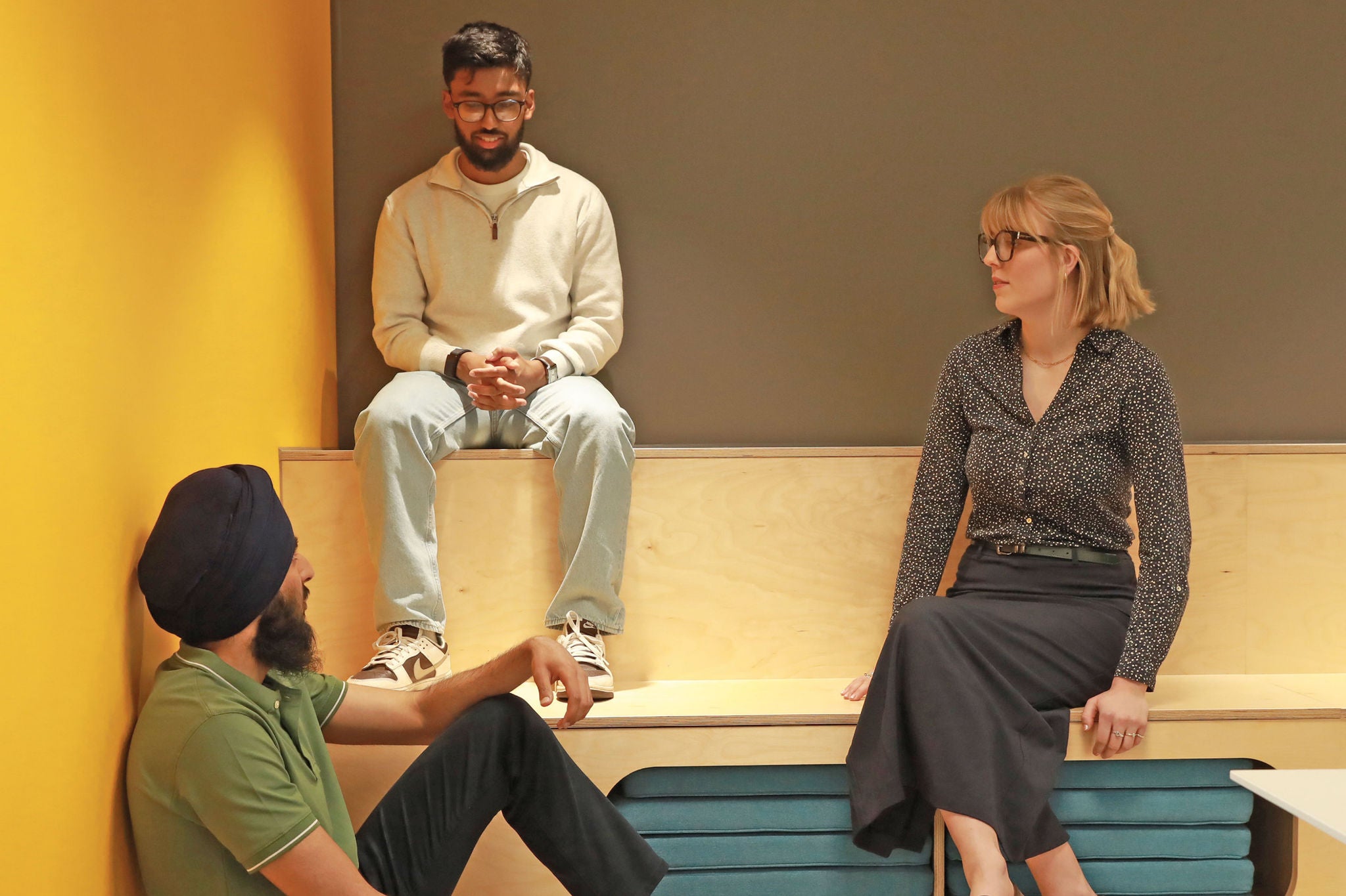 Three colleagues sitting in a collaborative space