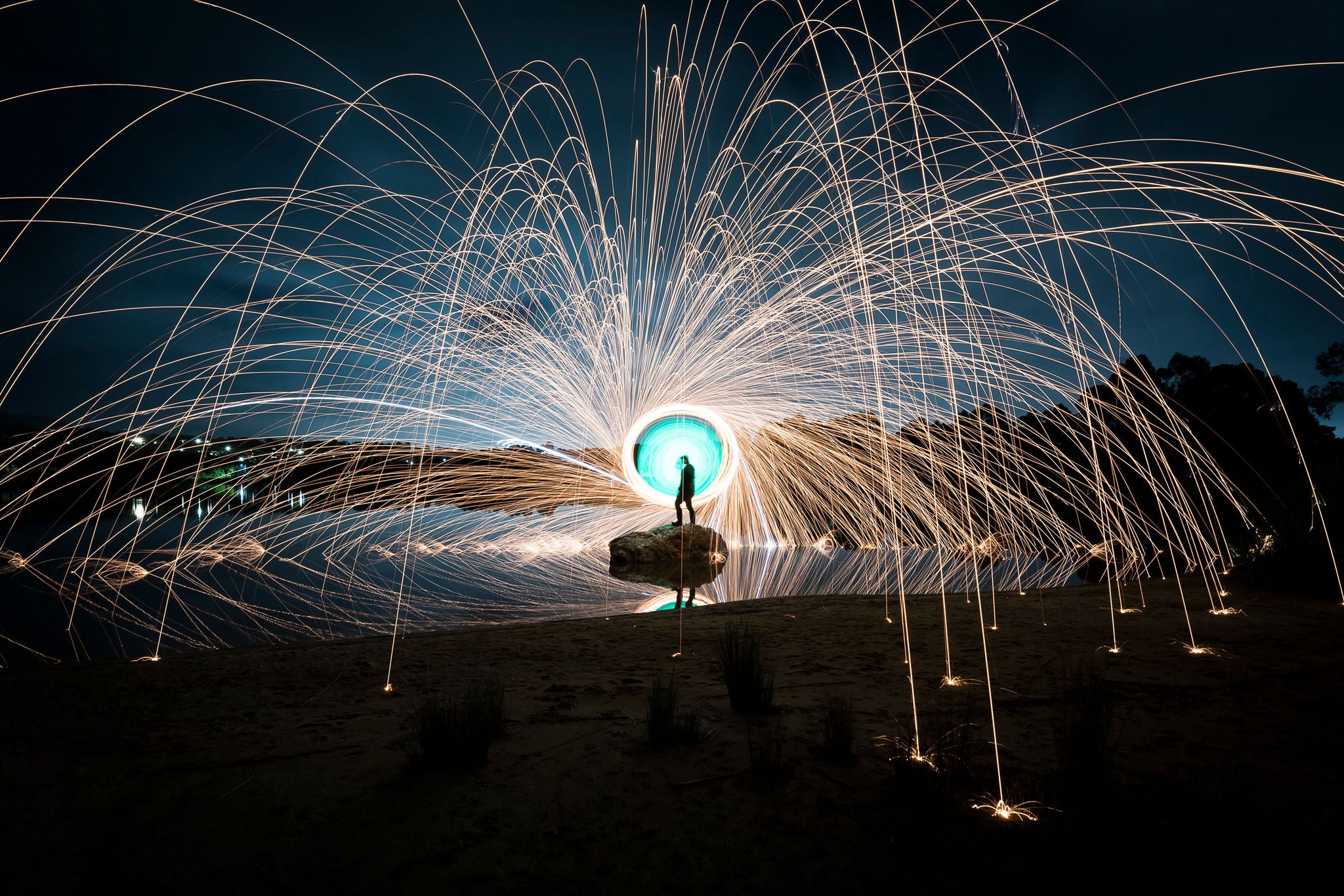 Une main tient une boule en cristal reflétant des feux d'artifice colorés.