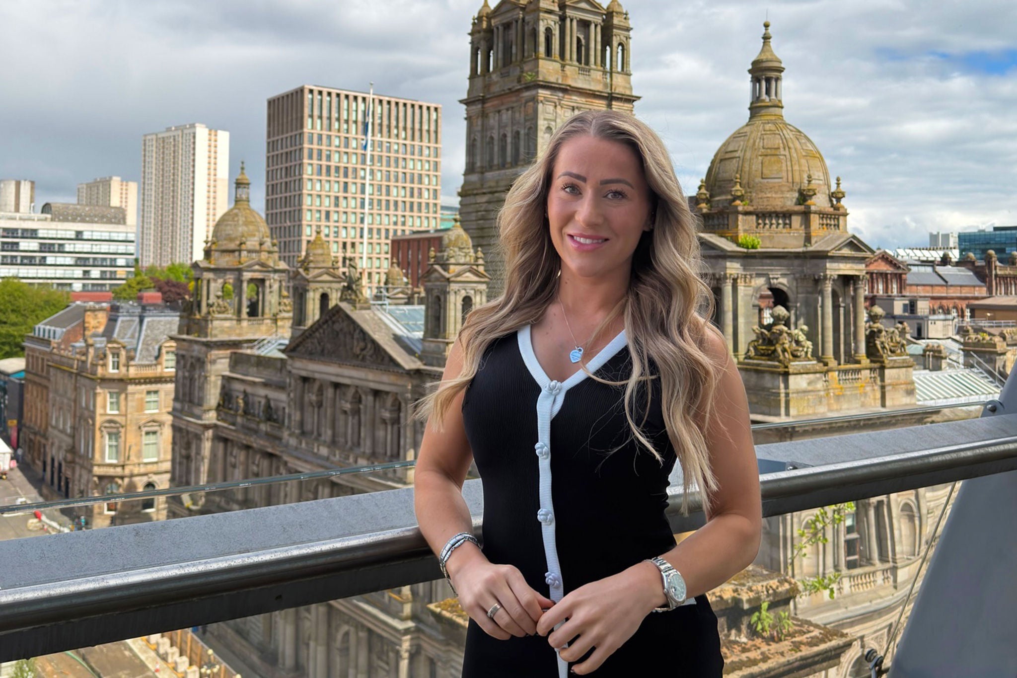 Person smiling with the Glasgow skyline behind
