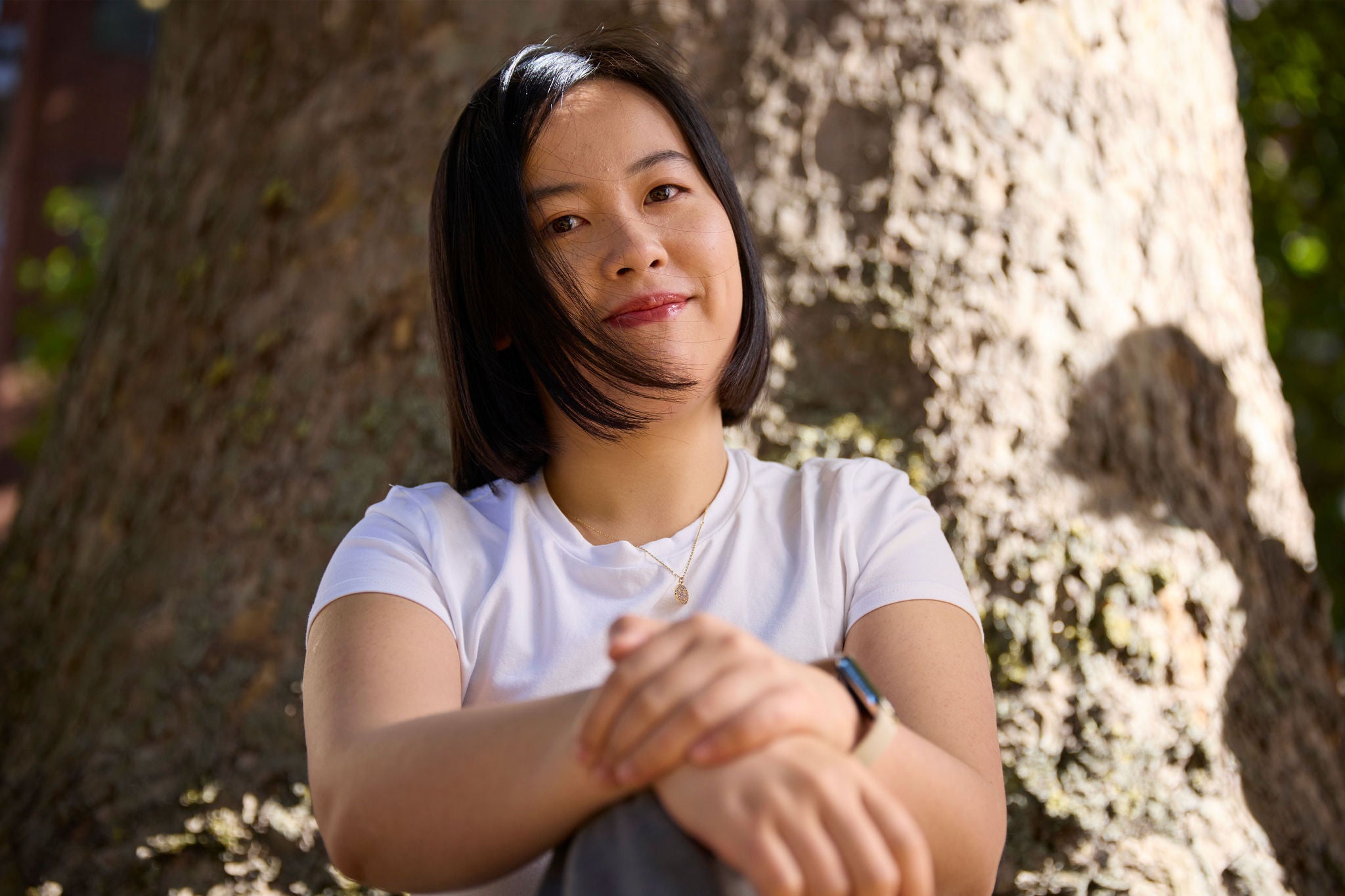 Person sitting in front of a tree