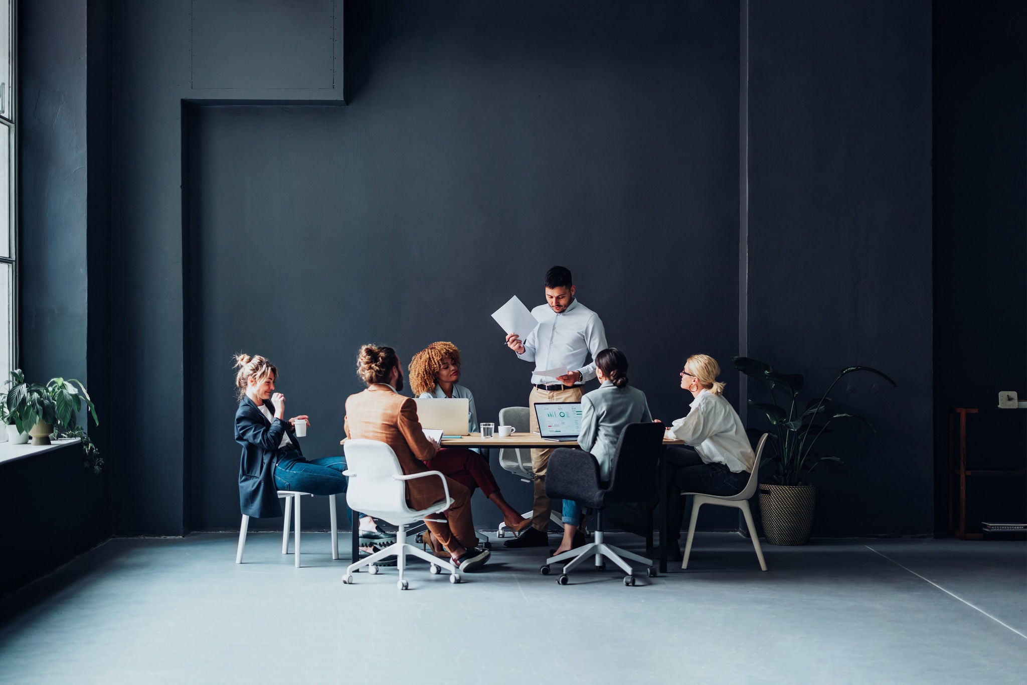 Multi ethnic team of six happy businessman and businesswoman discussing ideas together