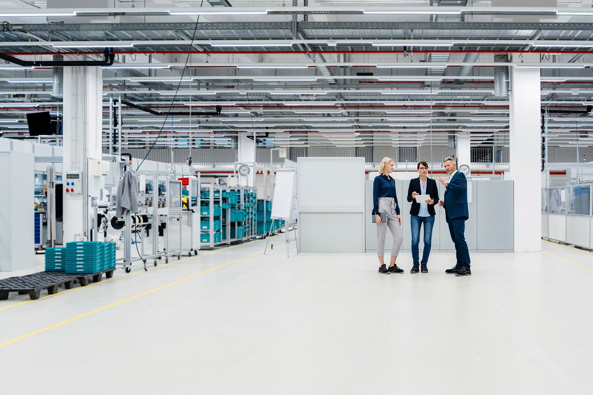 Three people talking factory floor