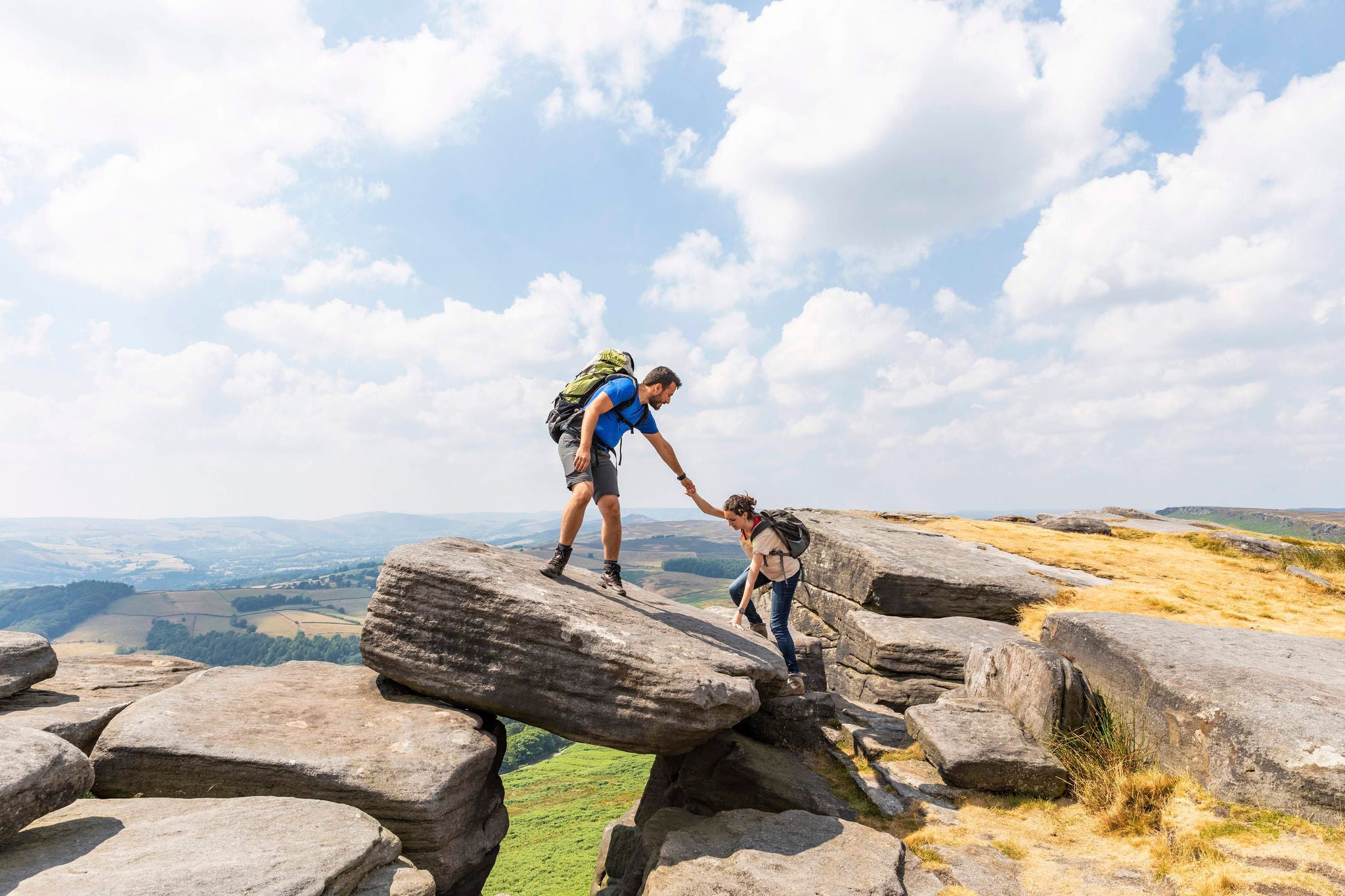 man helping women to cross the stone