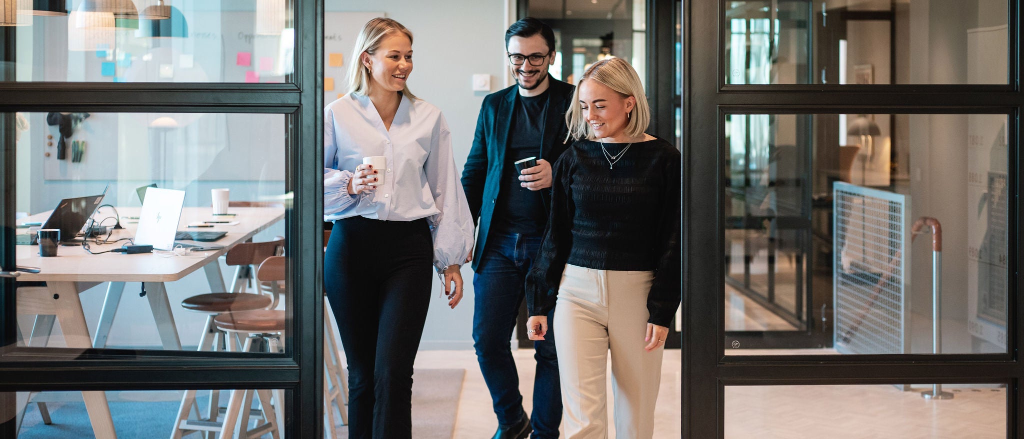 Professionals walking and discussing work in modern office corridor