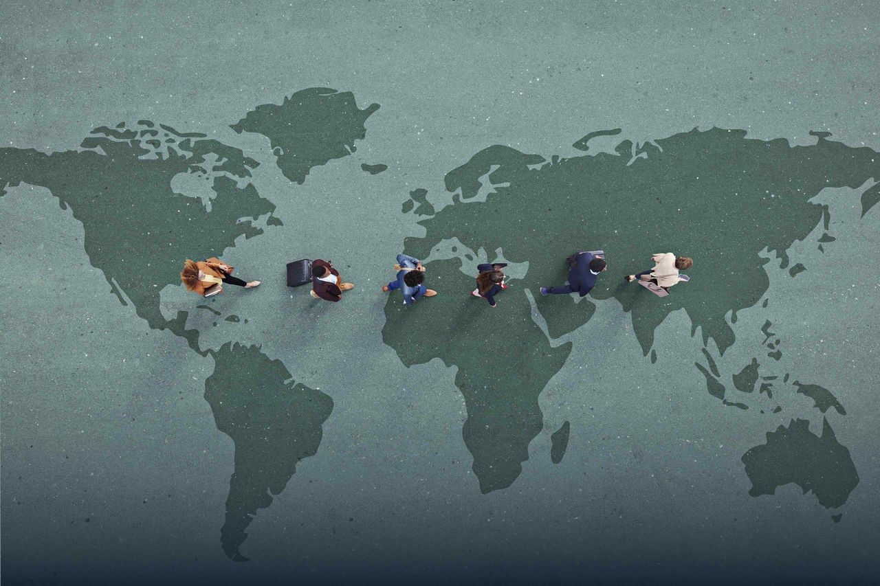 people standing on a continent map symbolizing around the world