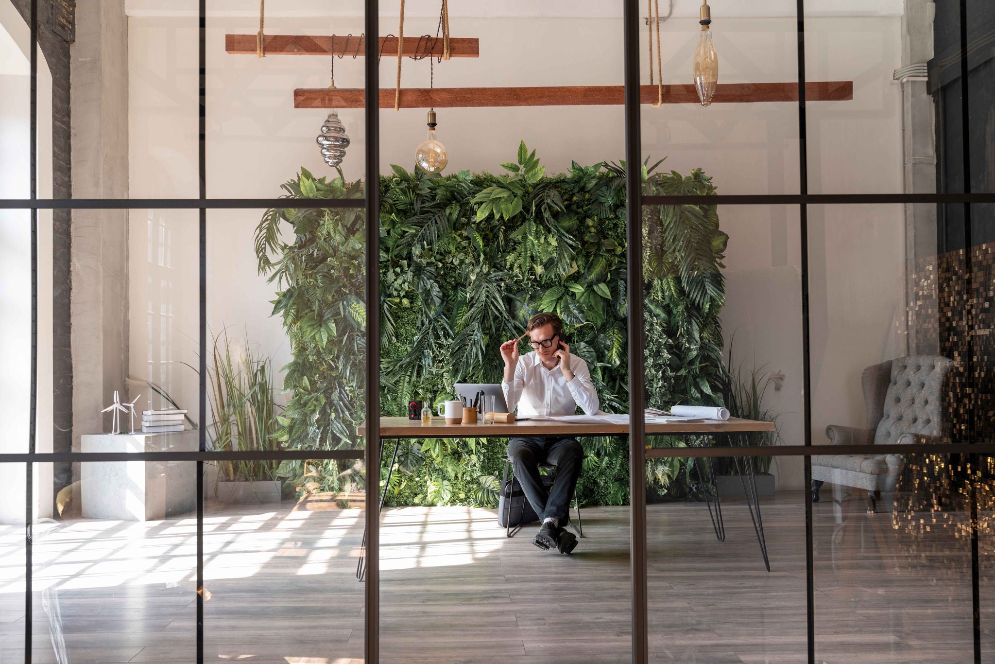 Forretningsmand sidder ved skrivebord og taler i telefon