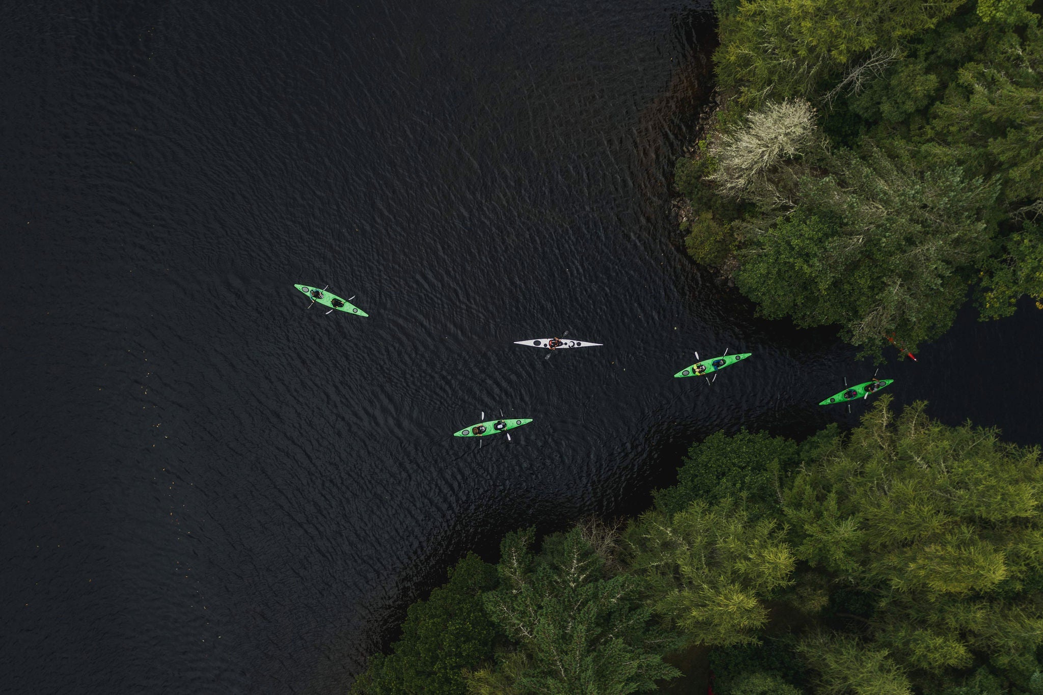 Aerial shot directly above kayakers on a Scottish Loch, Scottish Highlands, United Kingdom