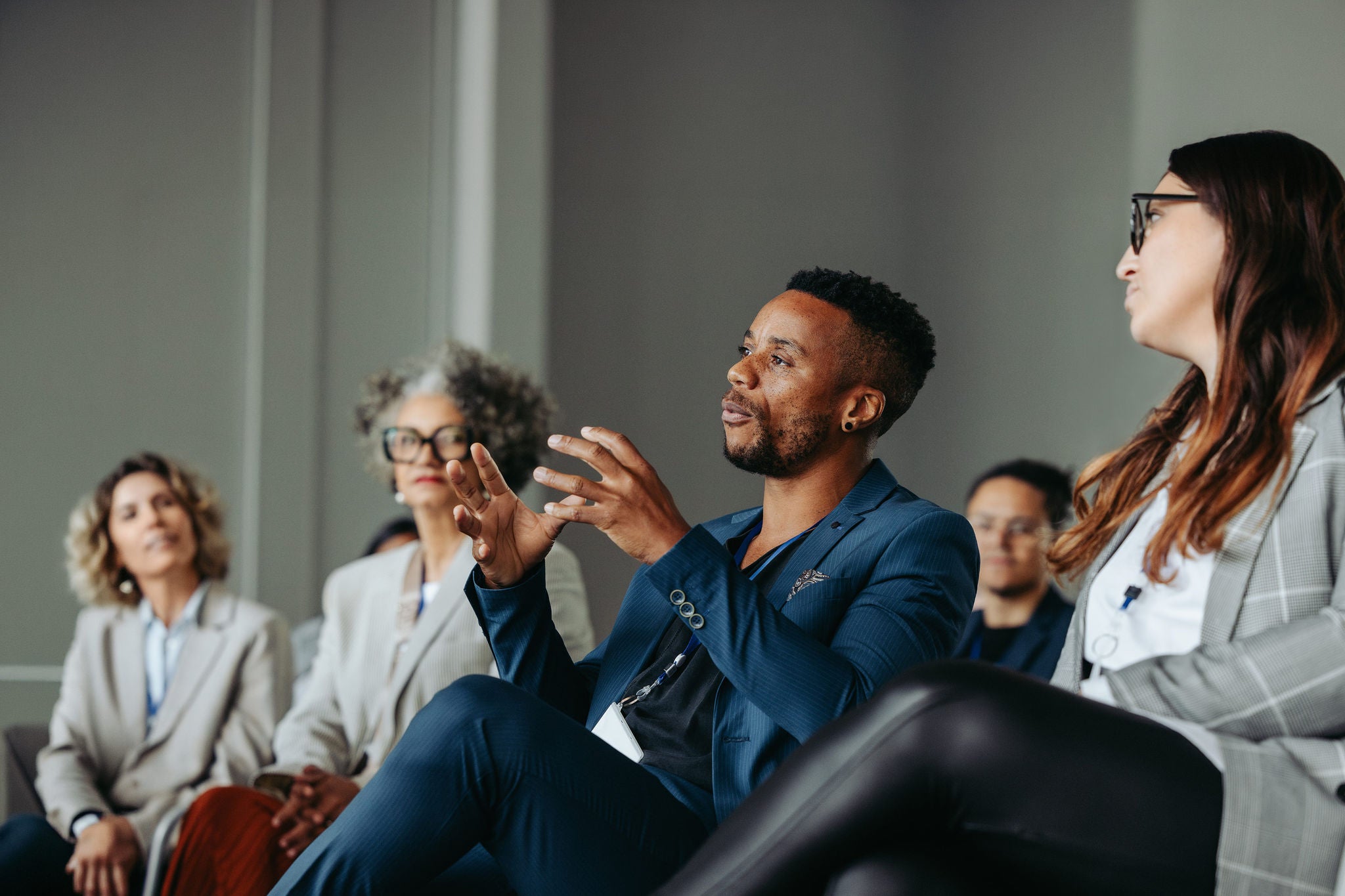Black business man passionately speaking during a workshop with colleagues in a professional conference setting.